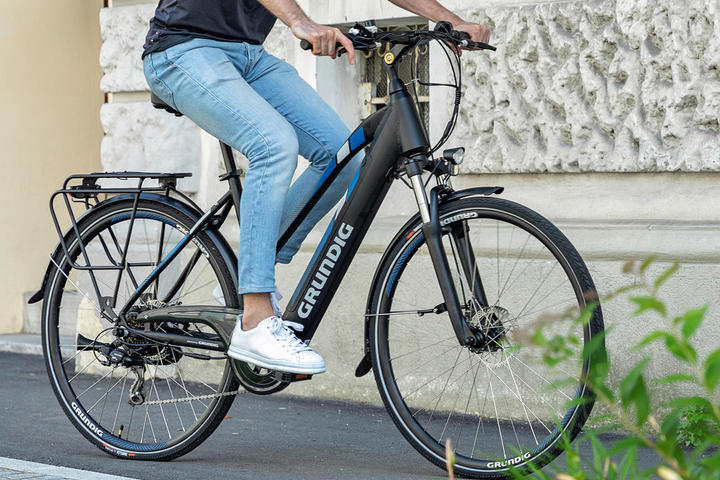 Ein Mann nutzt ein E-Bike, um entspannt auf der Straße zu fahren und die Umgebung zu erkunden.