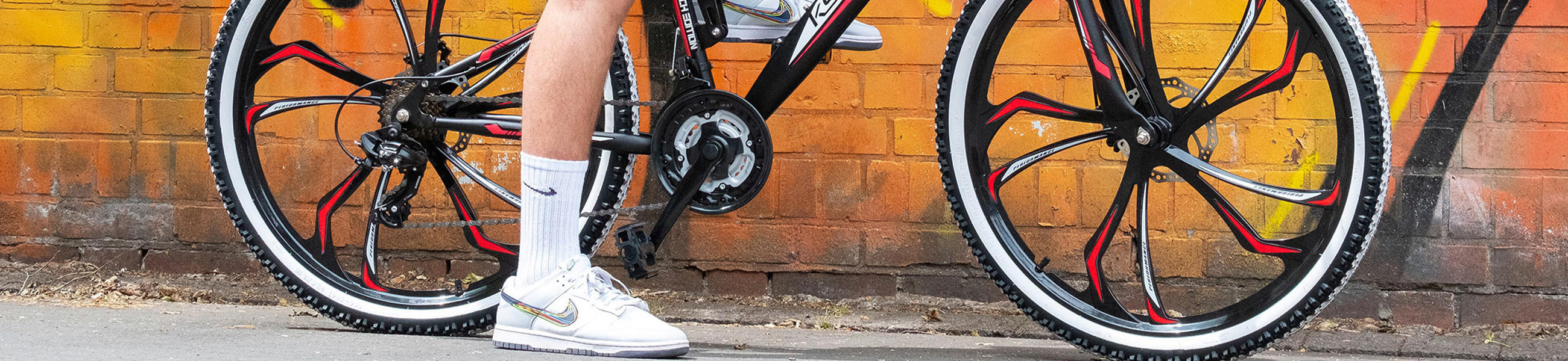 Ein Mann lehnt entspannt an seinem Fahrrad mit Ventilen.