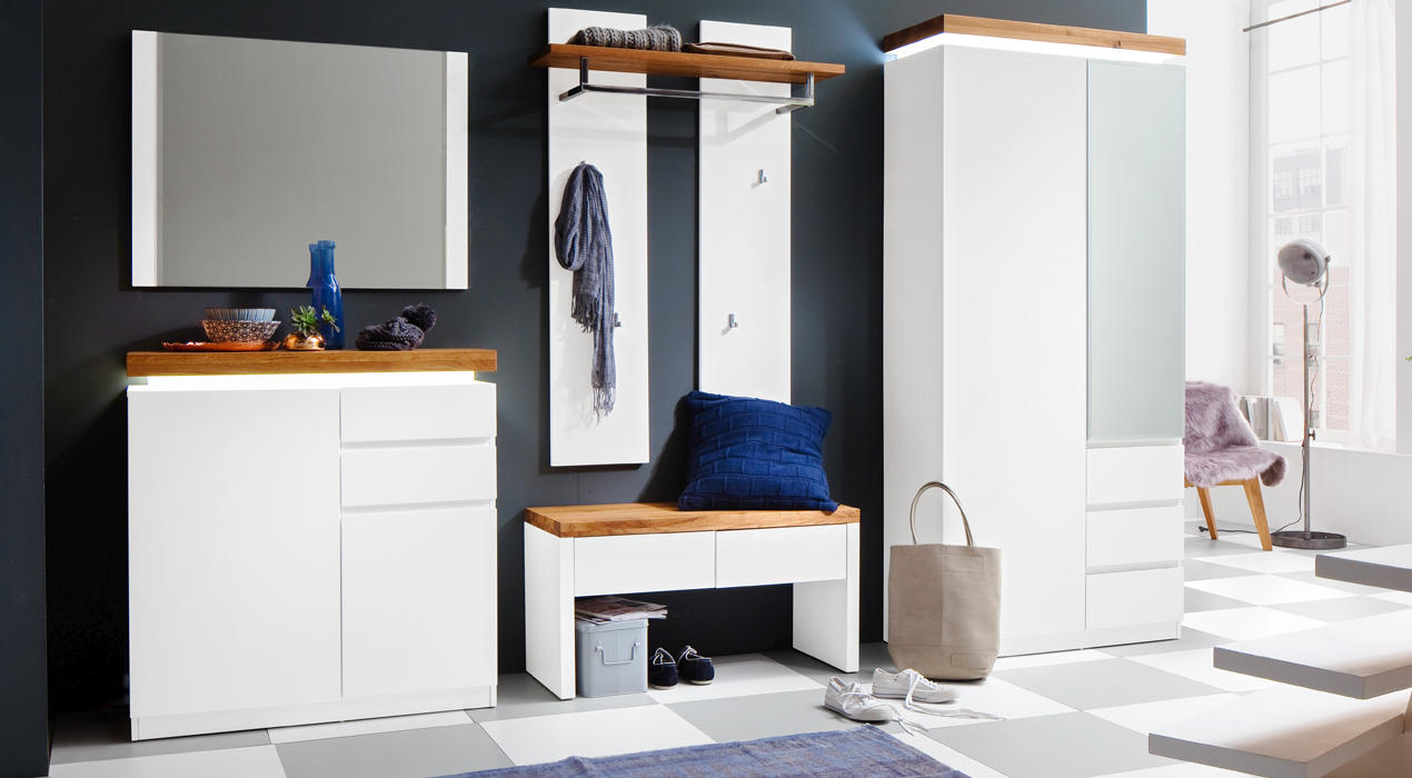 Moderner Flur mit weißen Möbeln und Holzakzenten: Spiegel, Kommode, Garderobe, Sitzbank mit blauer Polsterung, Schrank mit Glaselement und Deko