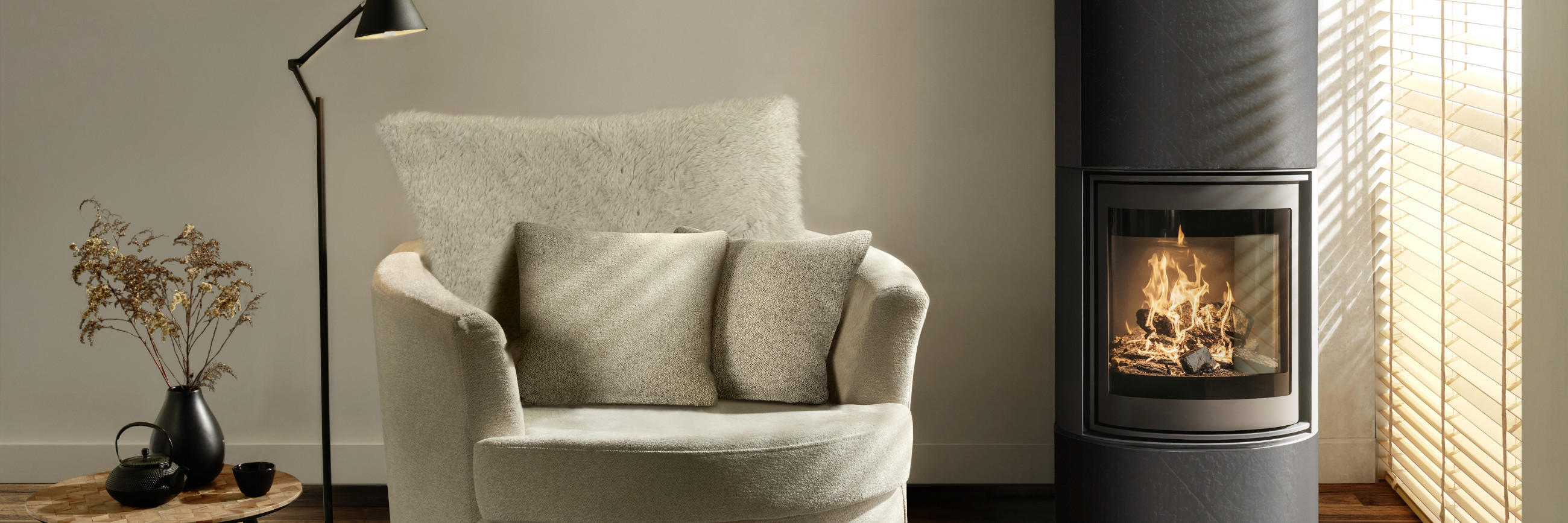 Gemütlicher heller Sessel neben einem Kamin