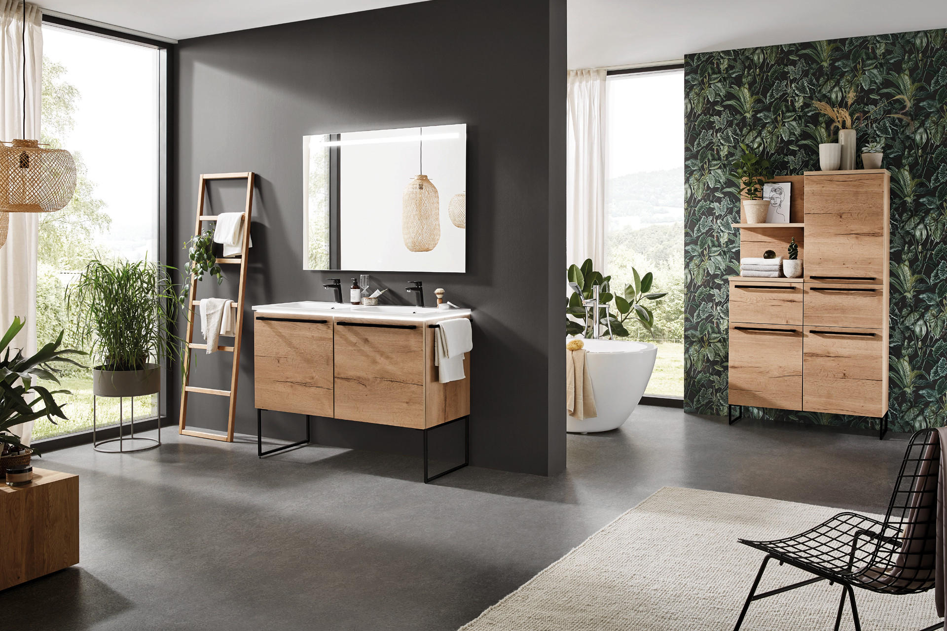 moderné kúpeľňové trendy, moderná kúpeľňa, drevený nábytok, dvojité umývadlo, veľké okno, voľne stojaca vaňa, šedá stena, zrkadlo s LED osvetlením, drevený rebrík, uteráky, zelená tapeta, čierna kovová stolička, koberec, svetlo v interiéri