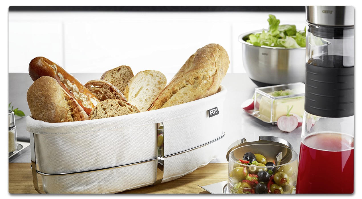 brotkorb mit Baguette und einer salatschüssel im Hintergrund