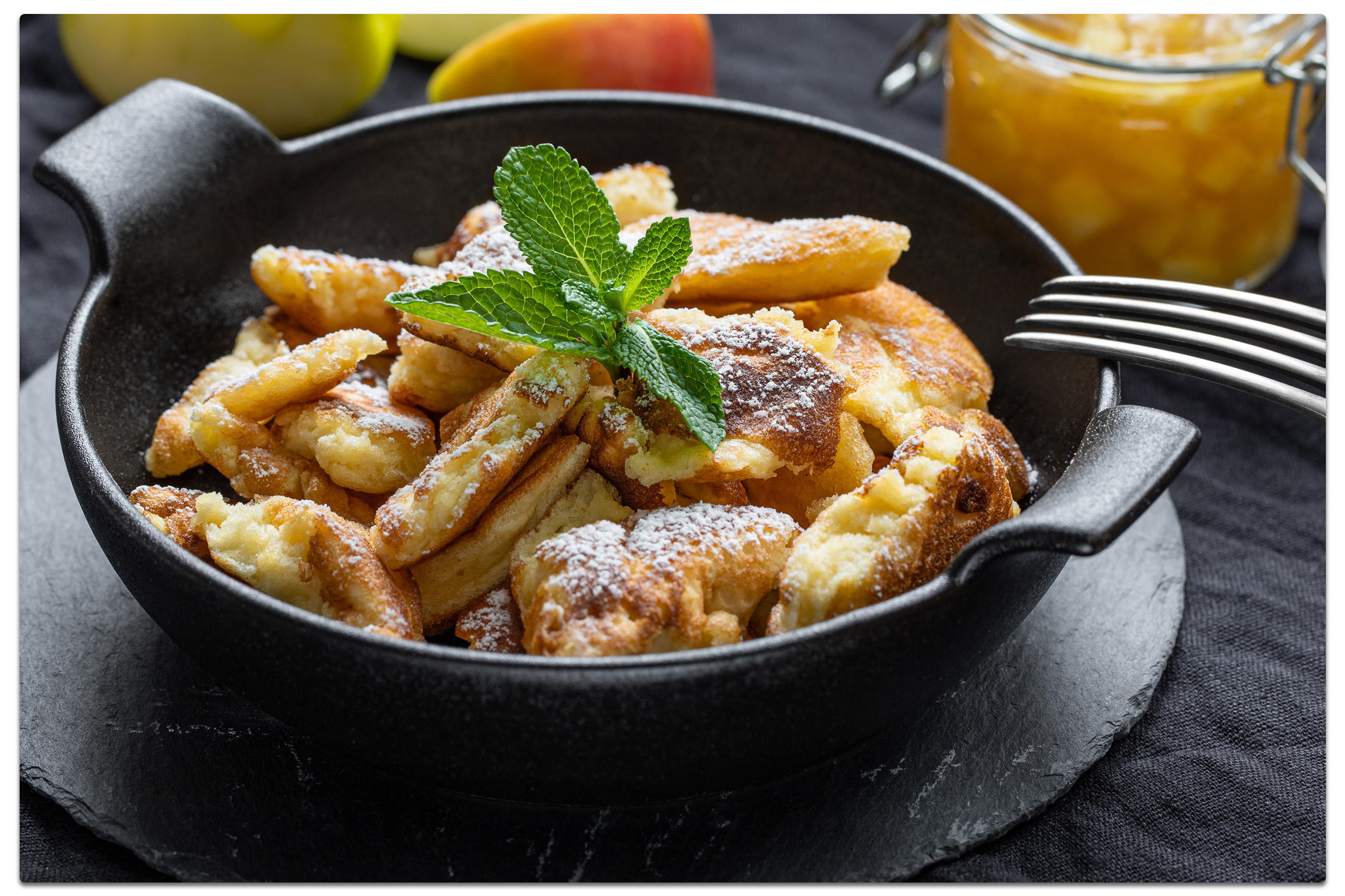 Eine Schüssel mit Kaiserschmarrn, garniert mit Puderzucker, ideal für ein Oktoberfest zu Hause.