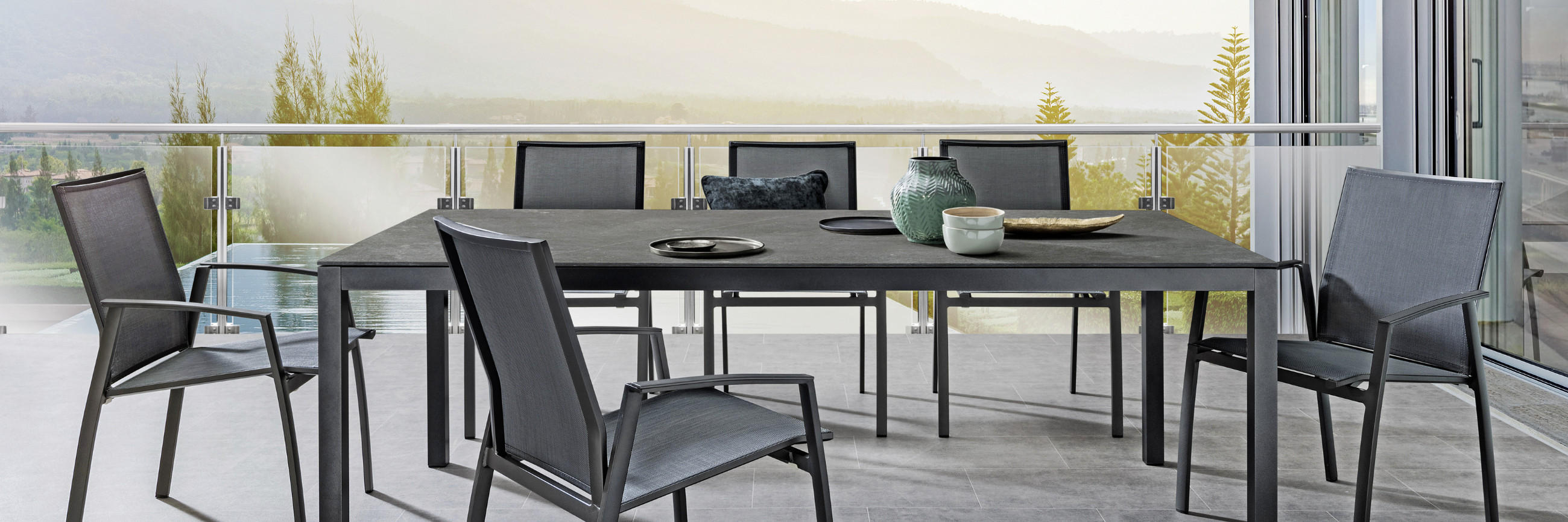 Grosser dunkelgrauer Tisch für die Terrasse mit Stühlen