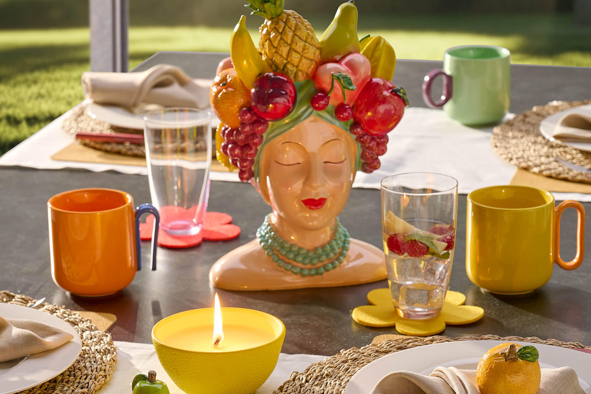 Bunt gedeckter Esstisch mit Obststatue