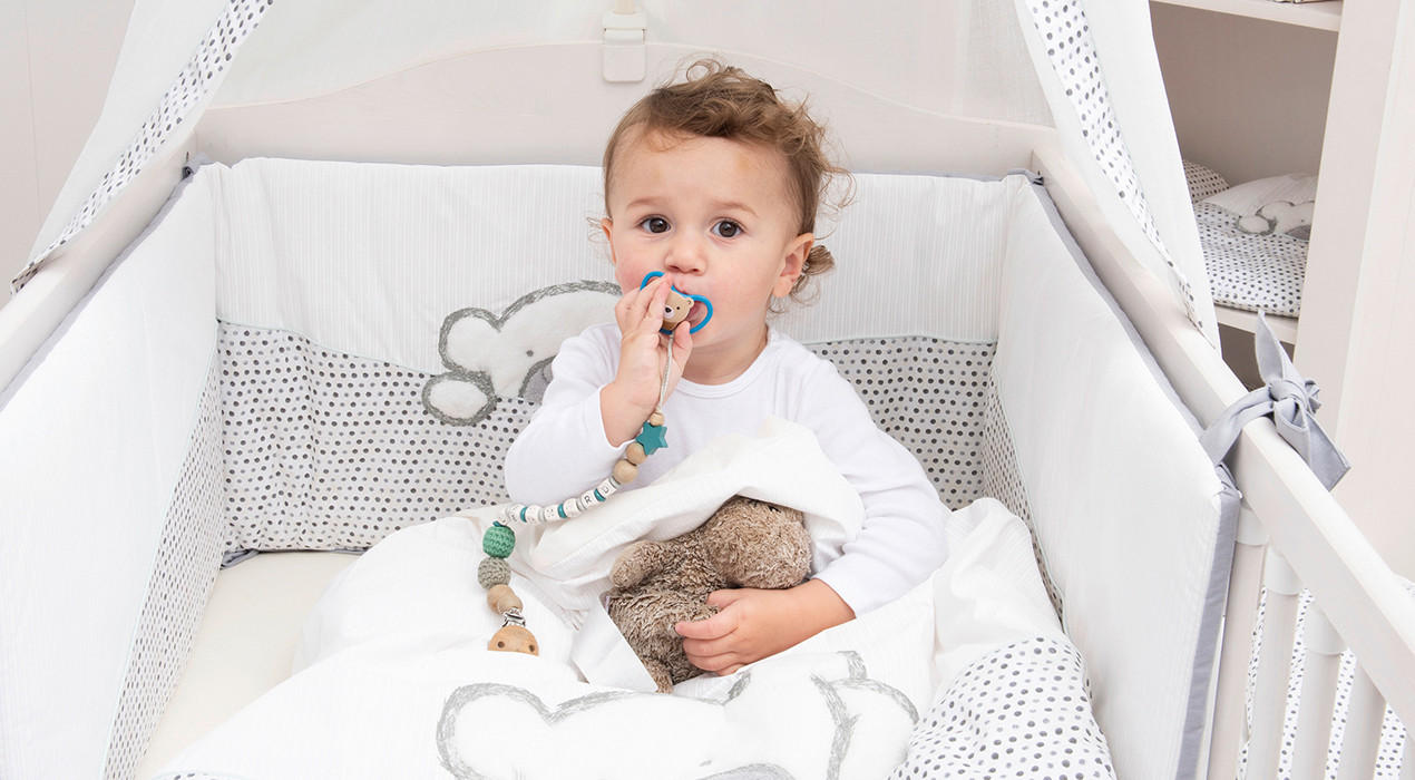 Baby im Bett mit Schnuller