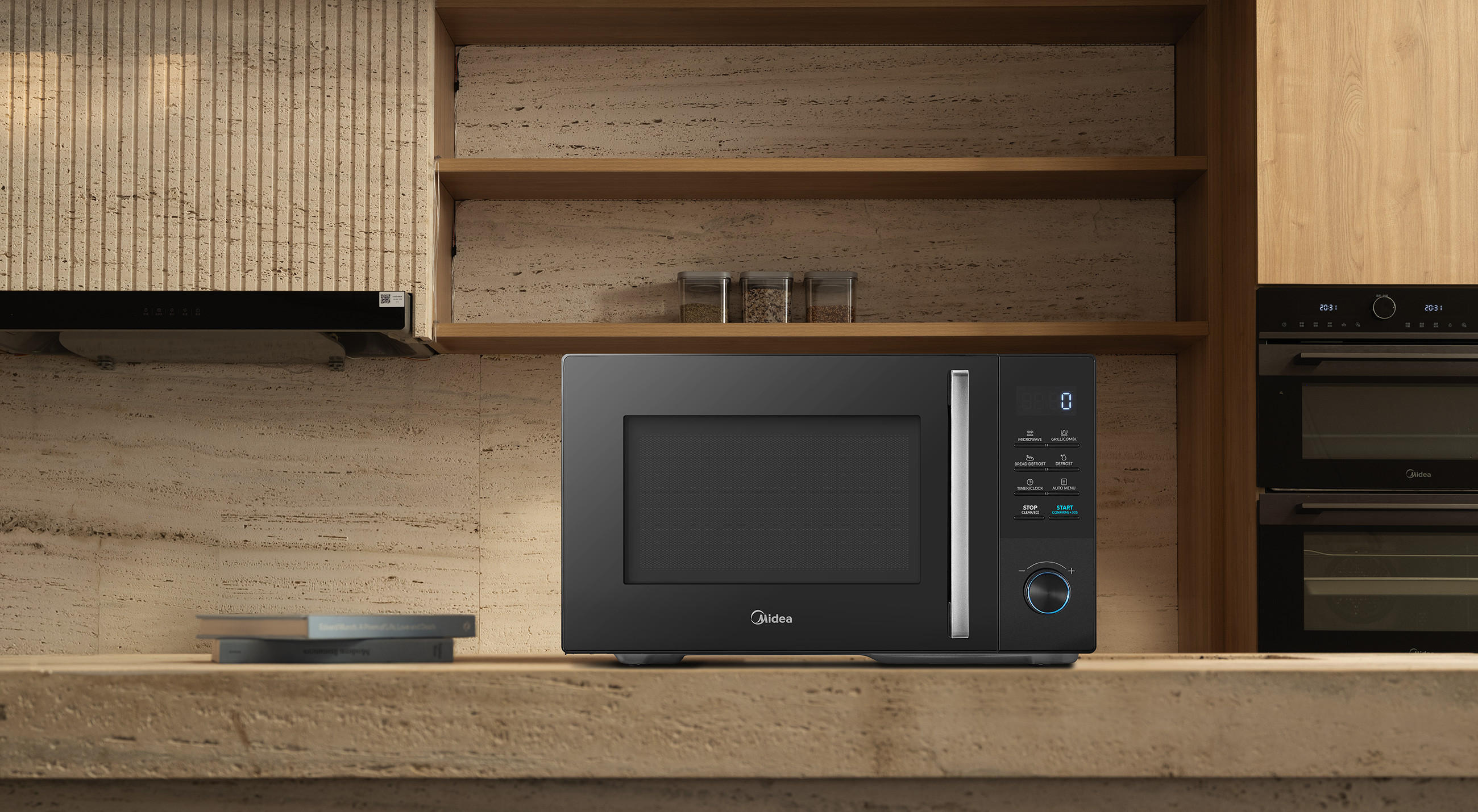 Midea Mikrowelle mit digitalem Bedienfeld auf einer Arbeitsplatte in einer modernen Küche; daneben ist ein integrierter Backofen in der Holzfront zu sehen.