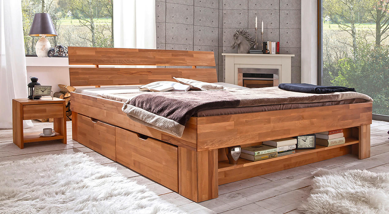 Massives Holzbett mit integriertem Stauraum, dekoriert mit Kissen und Decken, arrangiert in einem gemütlichen Schlafzimmer