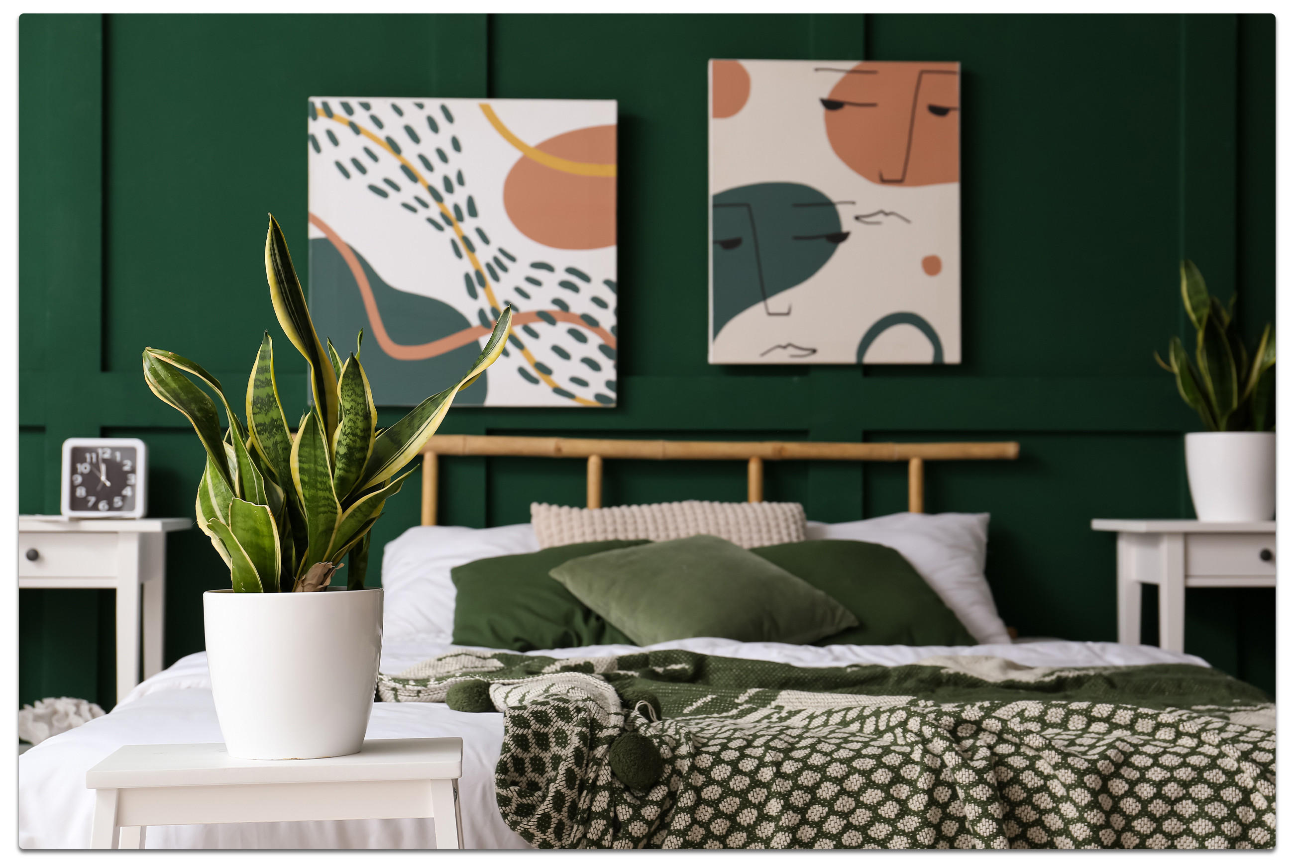 Grünes Schlafzimmer mit Doppelbett, Pflanzen auf Nachttischen und abstrakter Wandkunst.