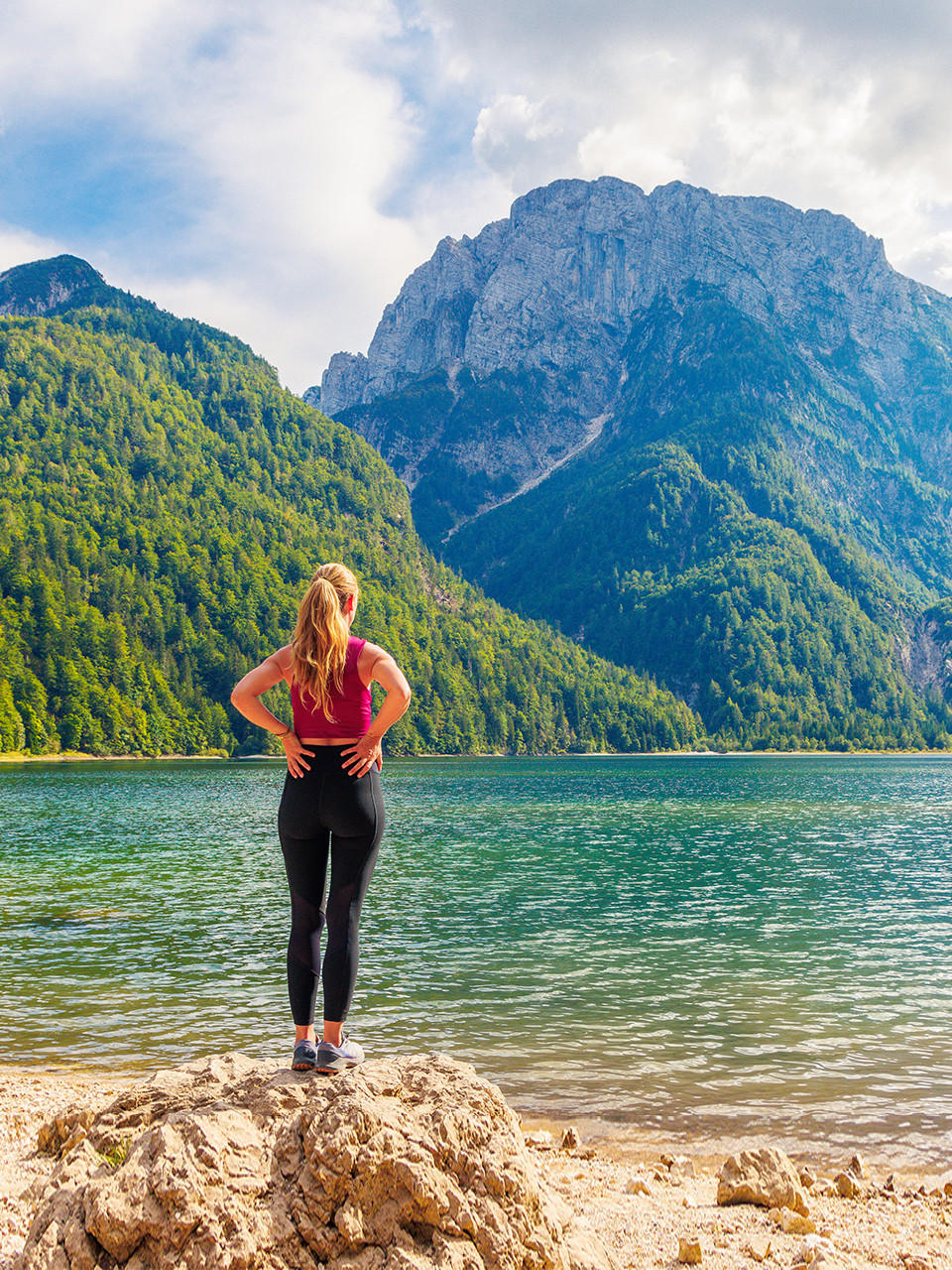 Eine Frau, die Allein vor dem See steht Und die Berge Mit Grüner Natur Betrachtet