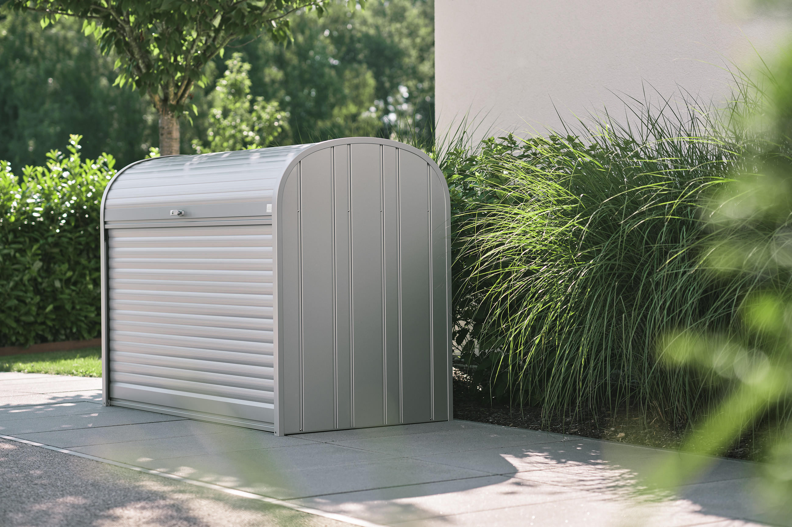 Silberne Mülltonnenbox von Biohort erzeugt harmonisches Gesamtbild vor dem Eigenheim.