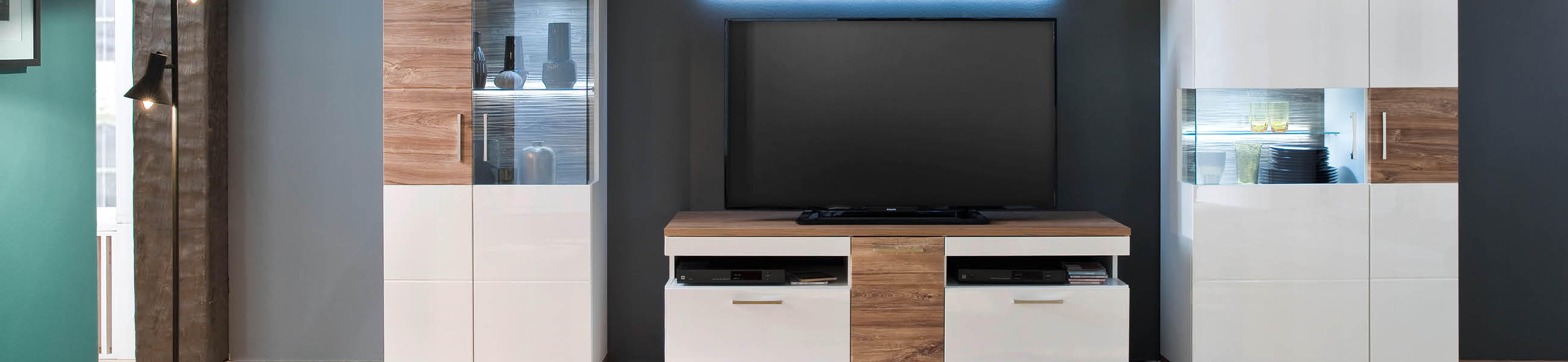 Moderne Wohnwand mit TV-Bereich, weißen und holzfarbenen Elementen, für ein stilvolles Wohnzimmer.