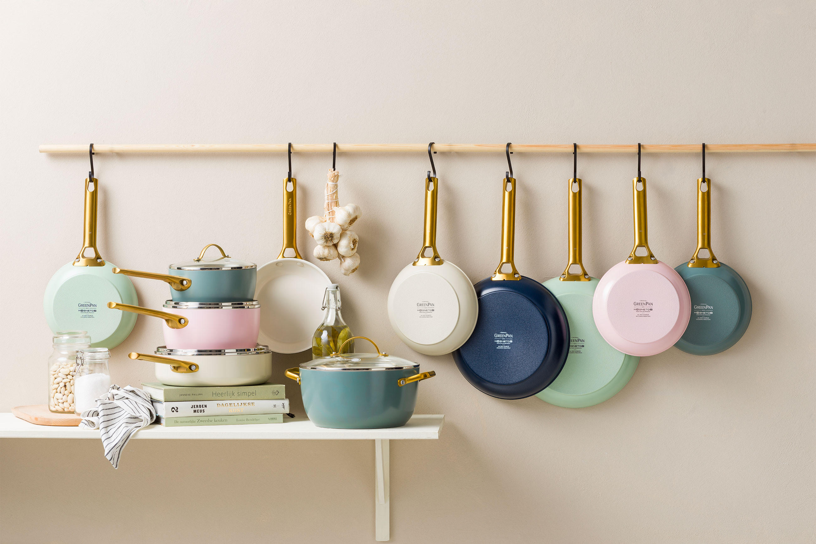 Eine Küchenregal mit verschiedenen Töpfen und Pfannen von GreenPan, die ordentlich aufgehängt sind.
