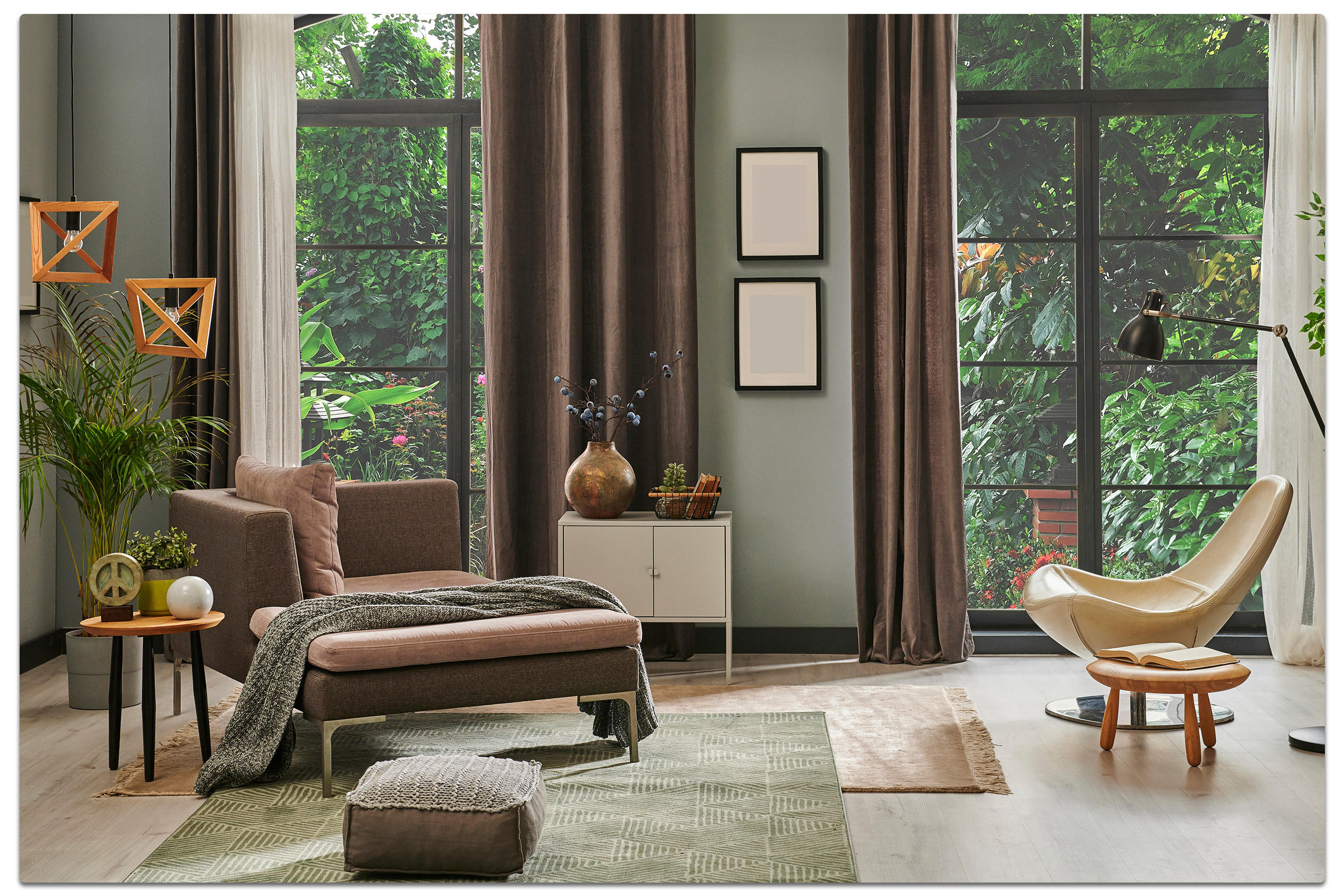 Modernes Wohnzimmer mit brauner Chaiselongue, hellem Sessel und Ottomane, dekorativen Elementen und großen Fenstern mit Blick ins Grüne – stilvolle Einrichtung mit Teppichen und warmen Farbtönen.