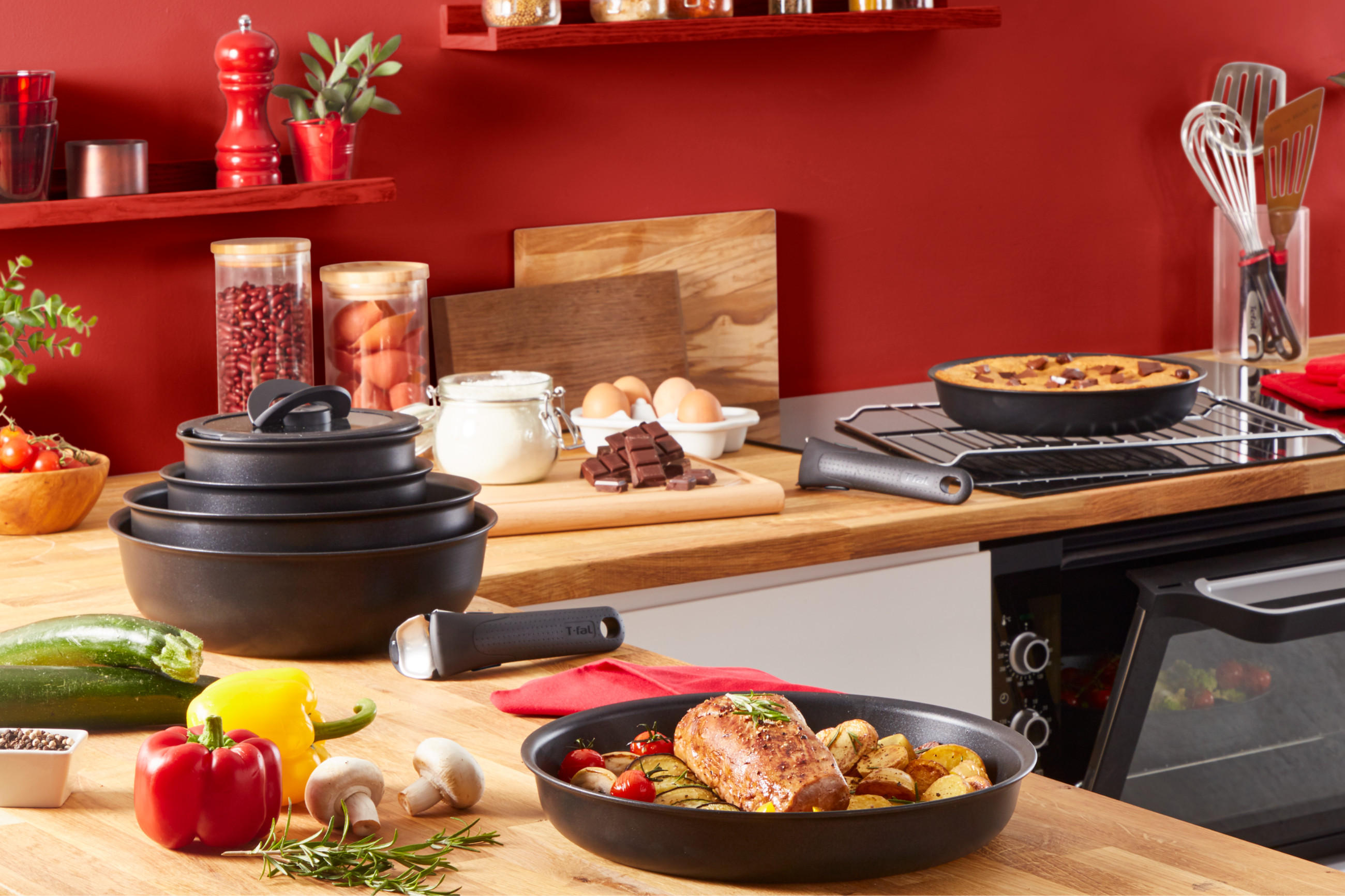 Pfannenset Ingenio von TEFAL in einer farbfrohe Küche, die viele Kochutensilien und Gerichte zeigt.