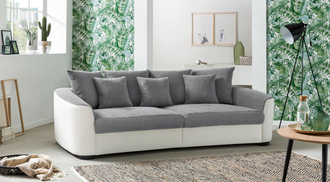 Weißes Big Sofa mit grauen Kissen