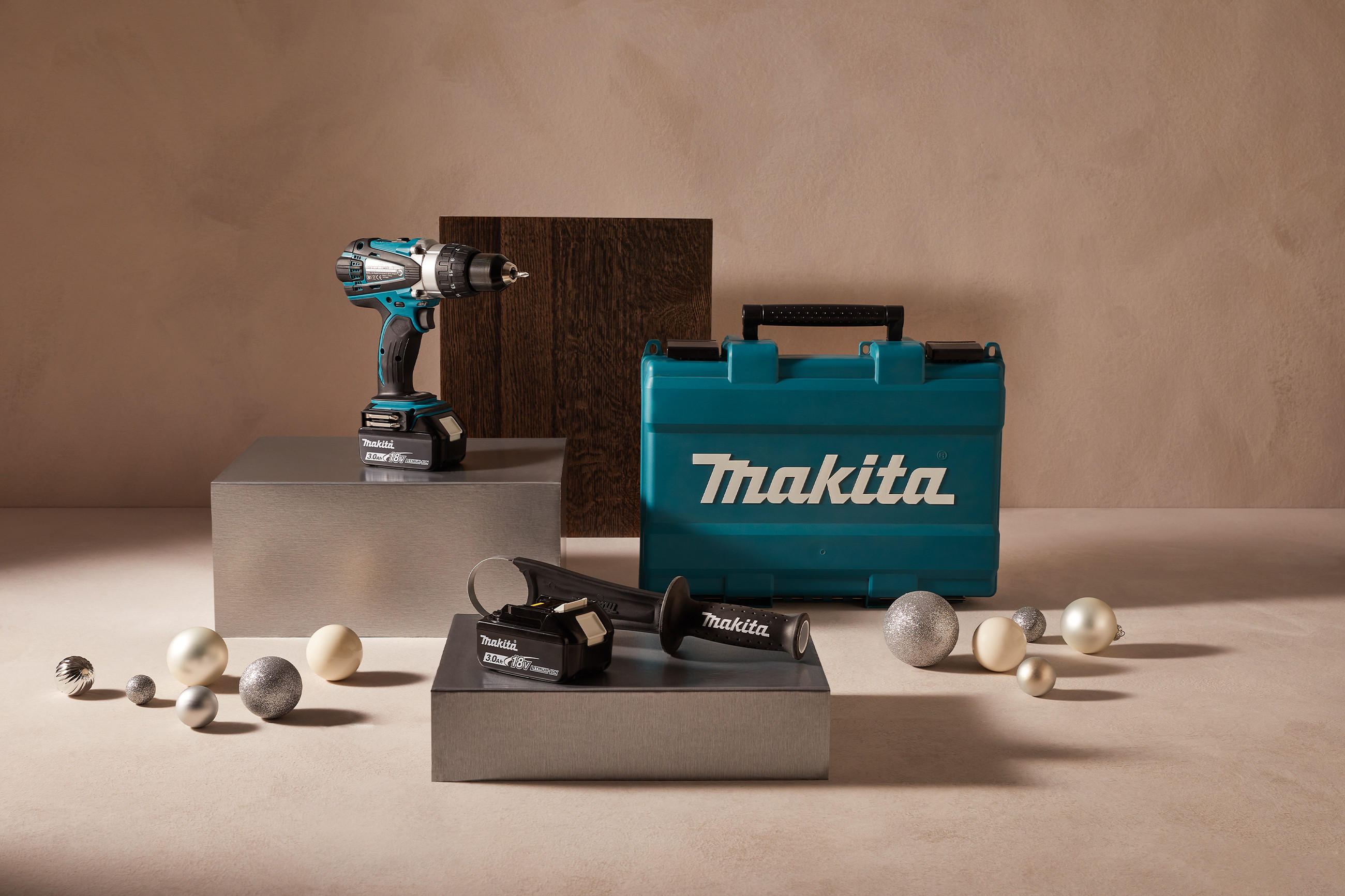 Bohrmaschine und Handwerkskoffer in weihnachtlicher Atmosphäre mit Christbaumkugeln