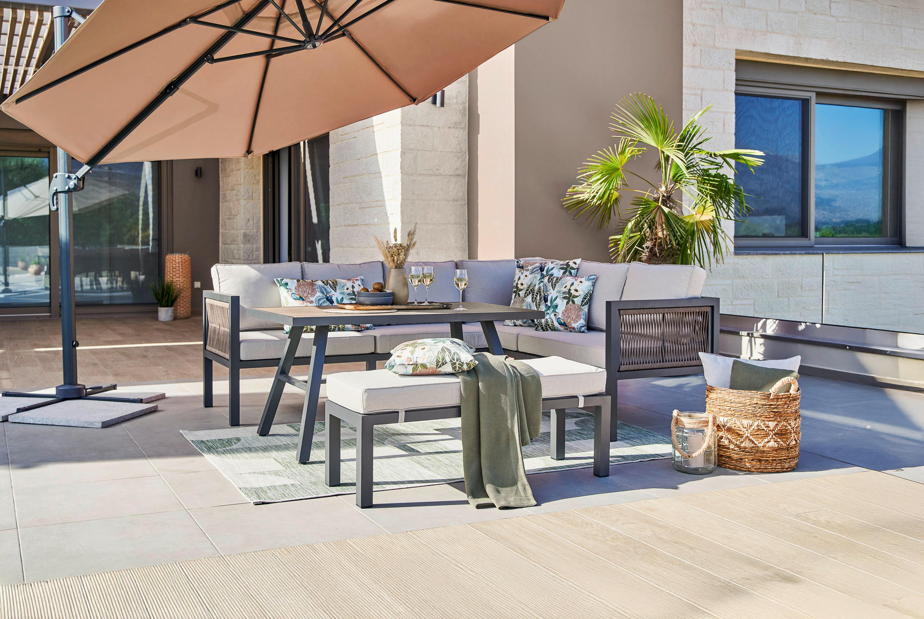 Moderne Gartengarnitur auf einer sonnigen Terrasse in dunkelgrau