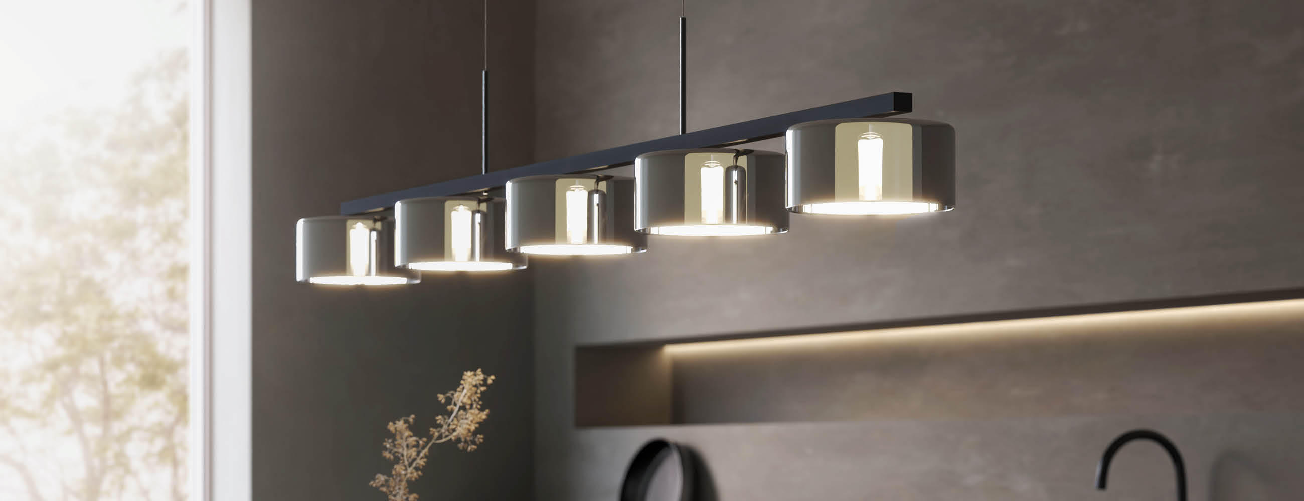 Moderne Pendelleuchte mit sechs zylindrischen Lampenschirmen über einem Esstisch in einem hellen Raum