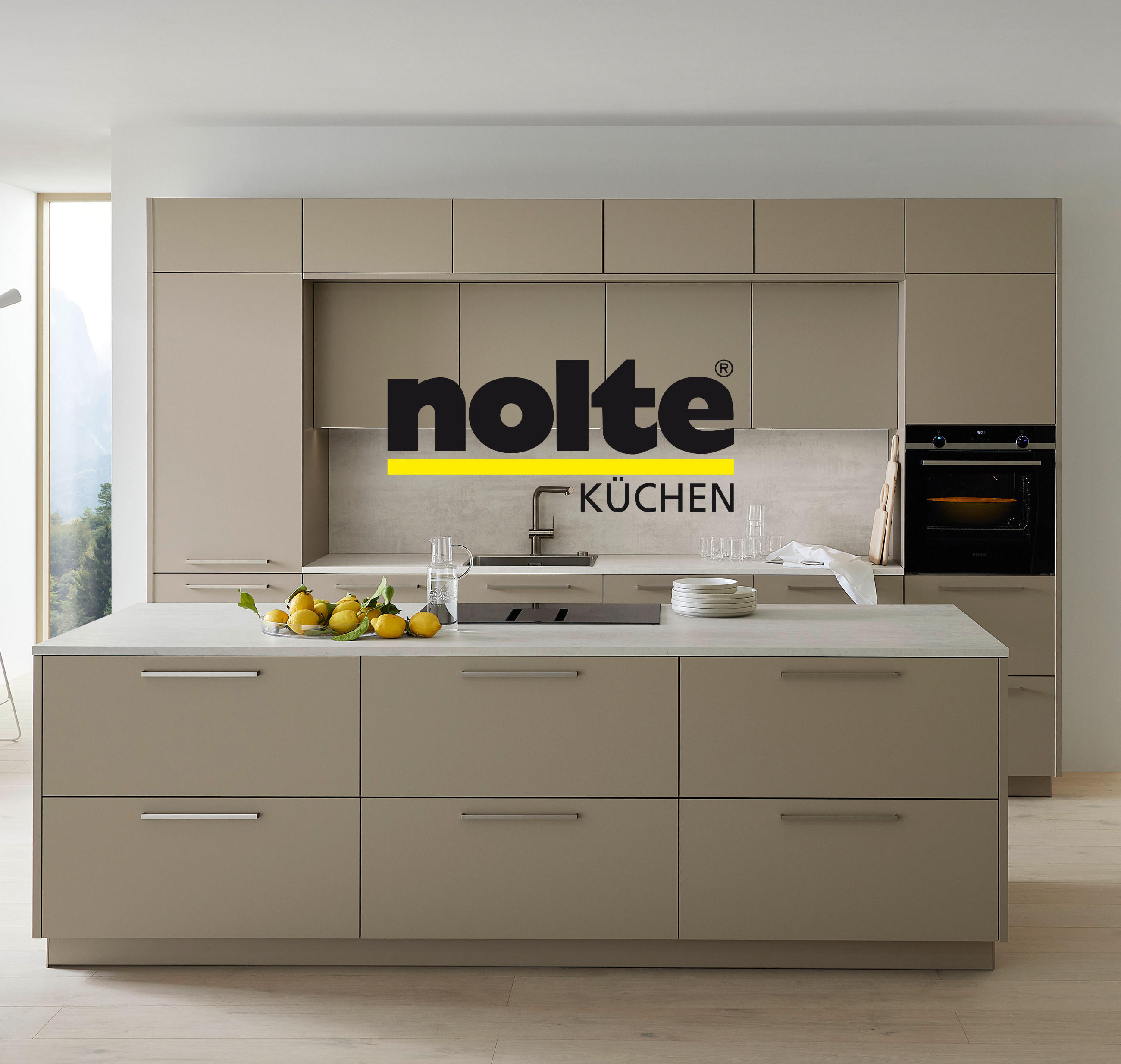 Stilvolle moderne Küche von NOLTE mit großer Kochinsel und elegantem, weißem Boden. Das NOLTE Küchen Markenlogo ist mittig platziert.