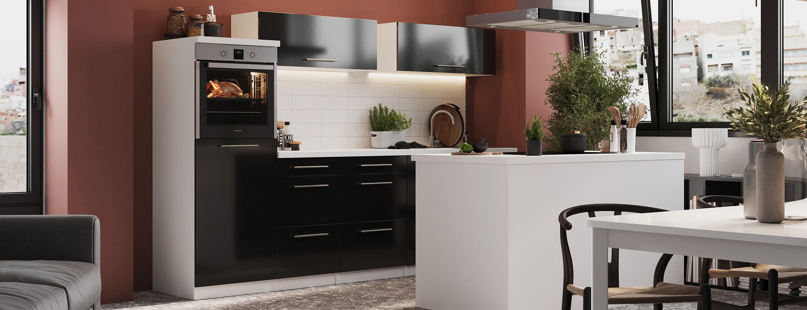 schwarze Küche mit weißer Kochinsel in hochglanz vor einer roten Wand mit Elektrogeräten in Silber.