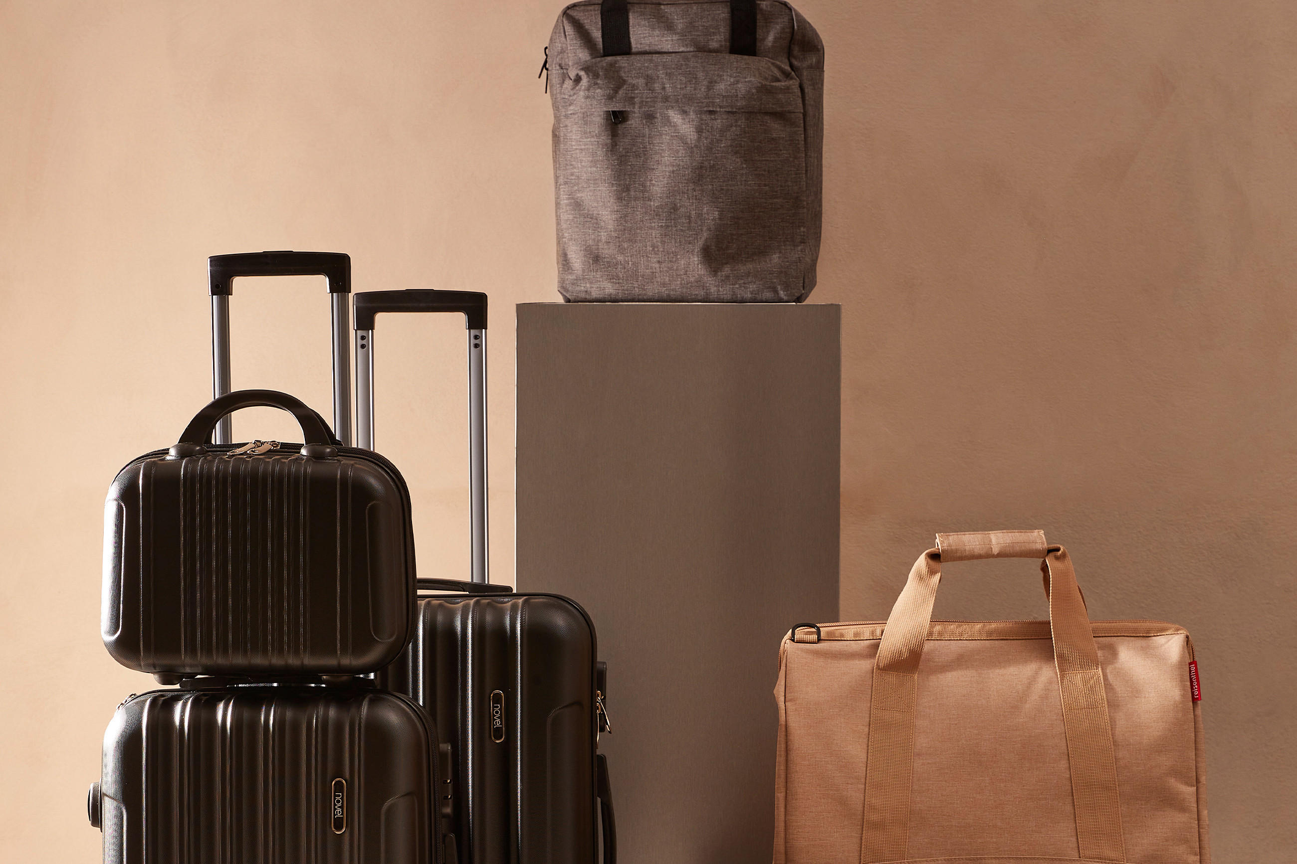 Eine Gruppe von Koffern und Taschen steht auf einer Holzbank.