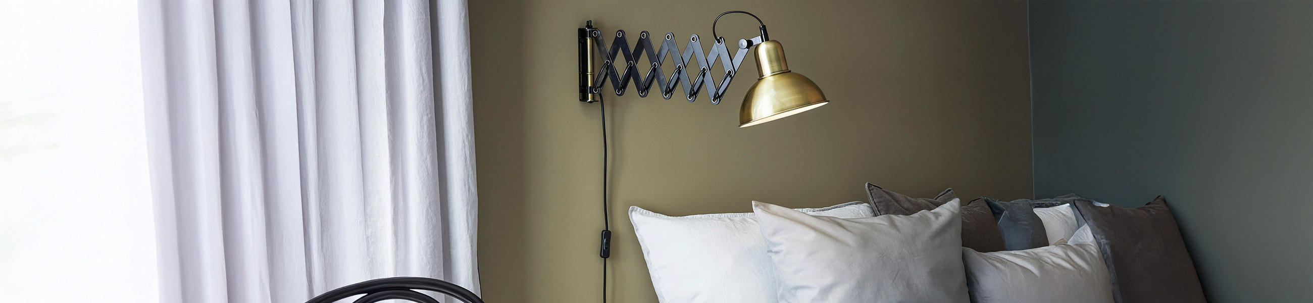 Scherenlampe an der Wand angebracht, um auf der Couch lesen zu können