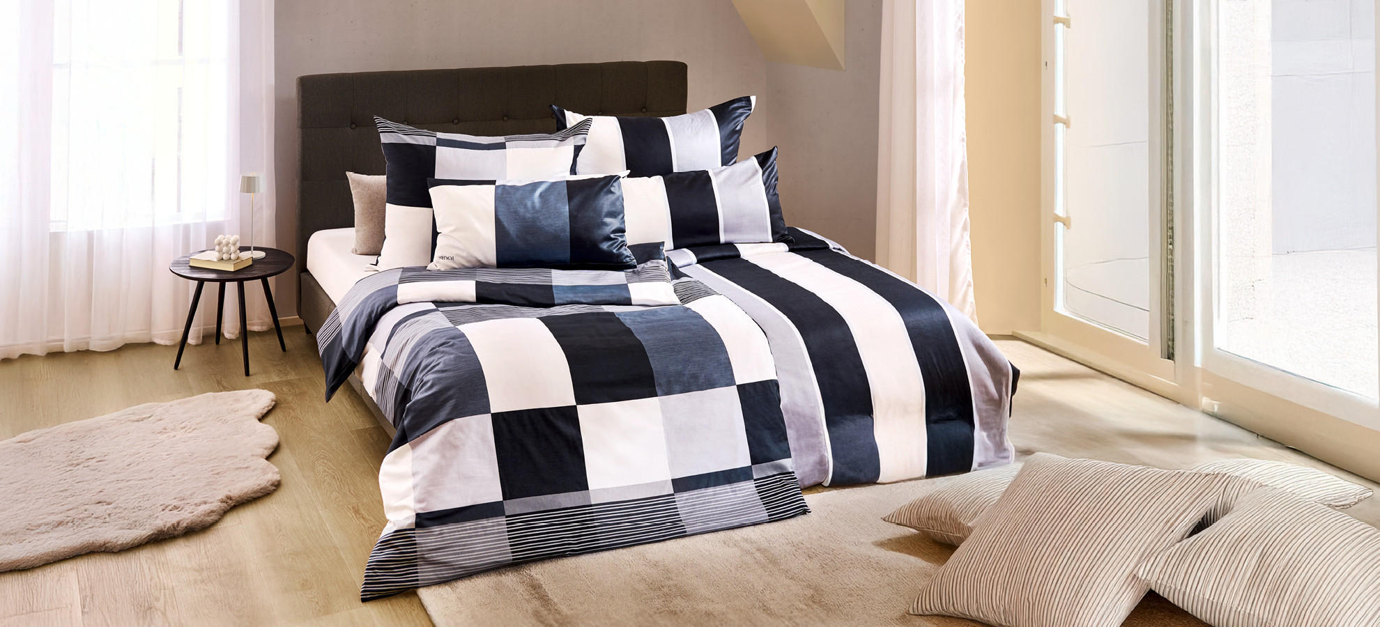 manželská posteľ, dekoračné kožušiny, čiernobiele posteľné prádlo, prúžkované obliečky