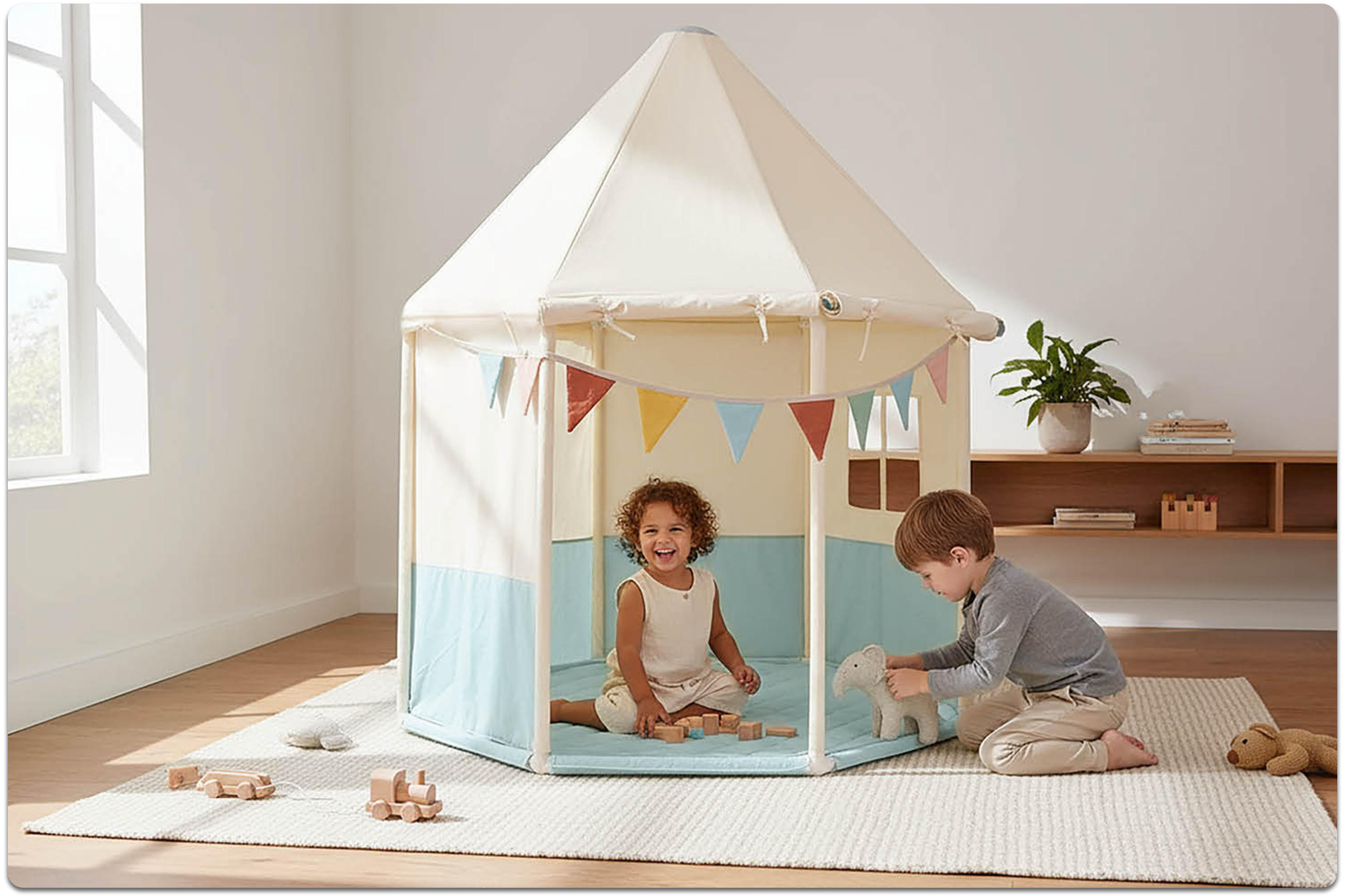 Zwei Kinder sitzen auf einem Teppich vor einem kleinen Spielzelt mit Dach und Wimpelkette, eines hält ein Stofftier.