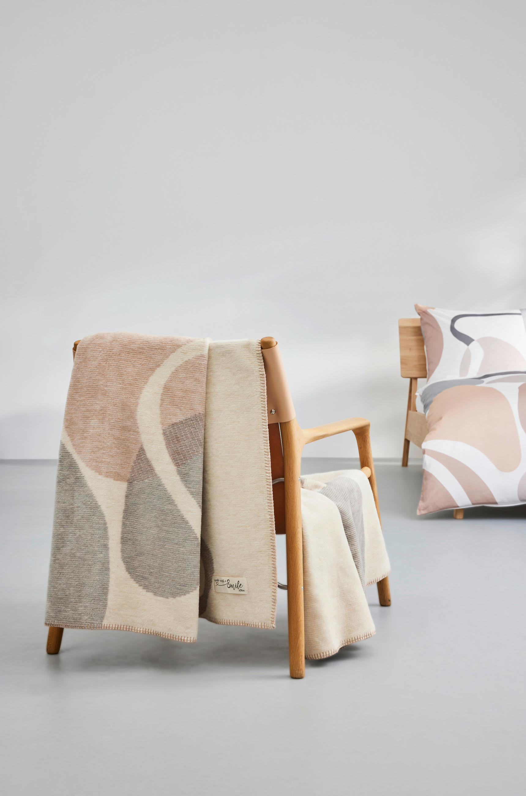 Udoben stol z odejo z vzorcem, ki je nameščena na naslonu.