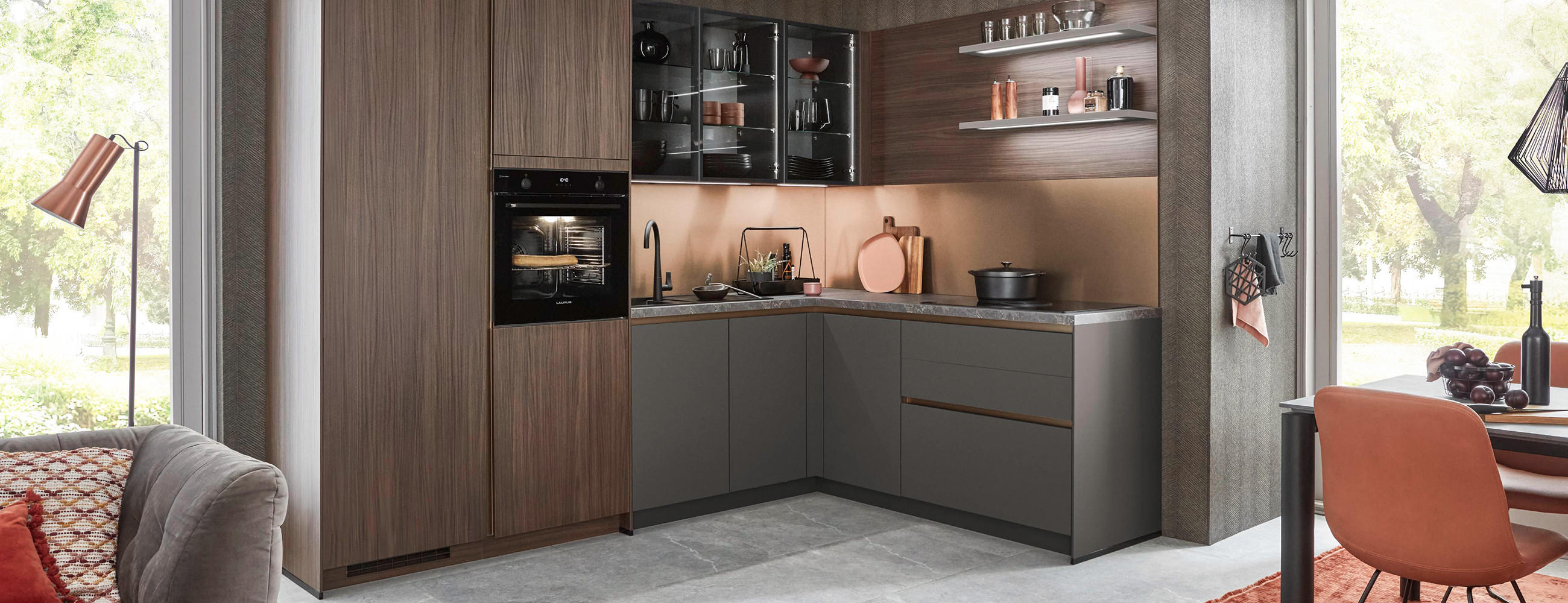 Moderne Küche in L-Form, mit dunklen Fronten und indirekter Beleuchtung.