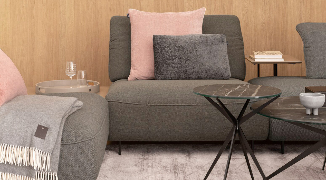 graue couch mit rosaner Decke