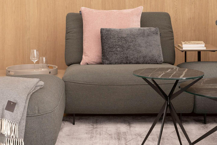 graue couch mit rosaner Decke