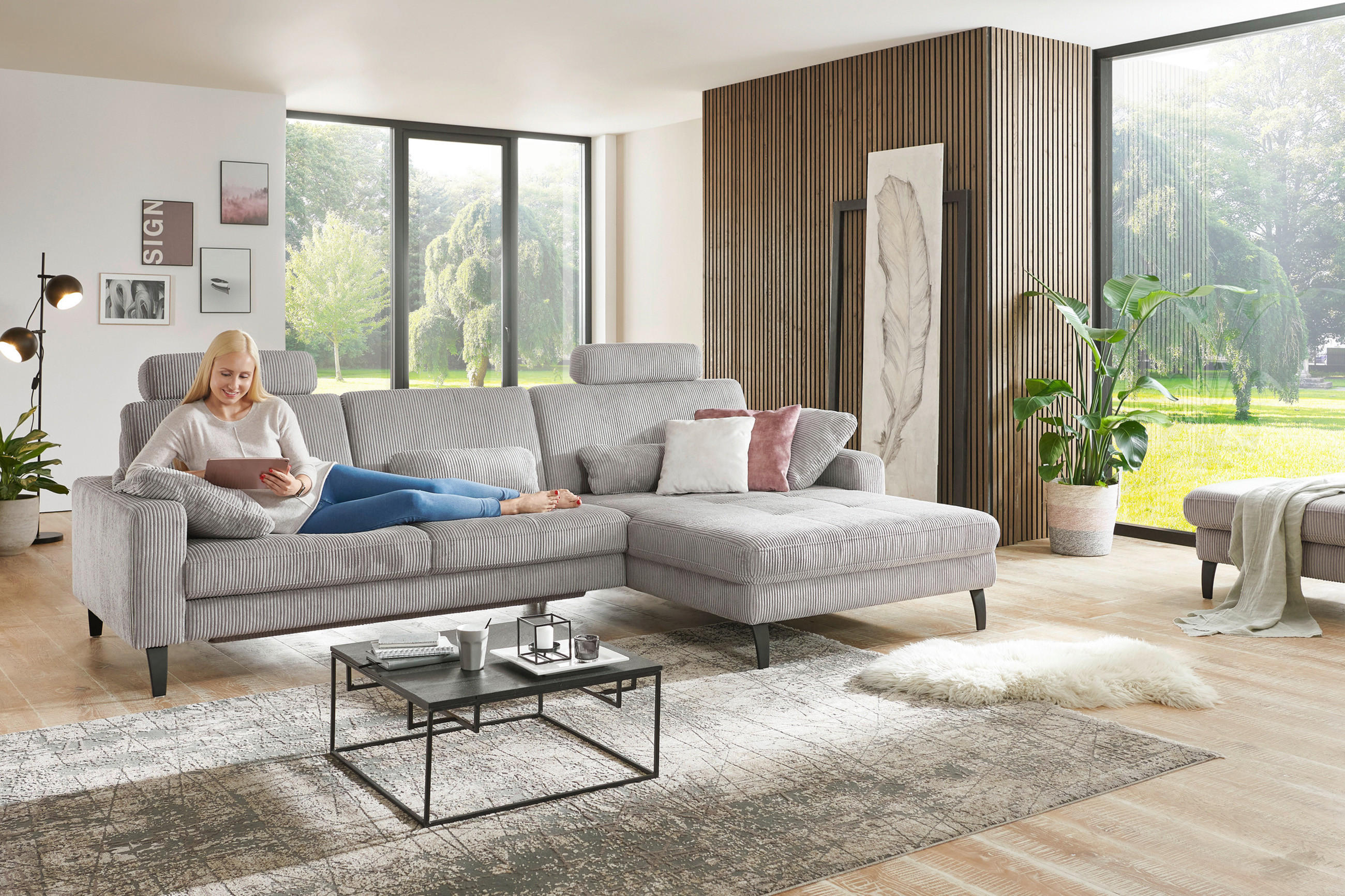 Frau liegend auf grauer Couch