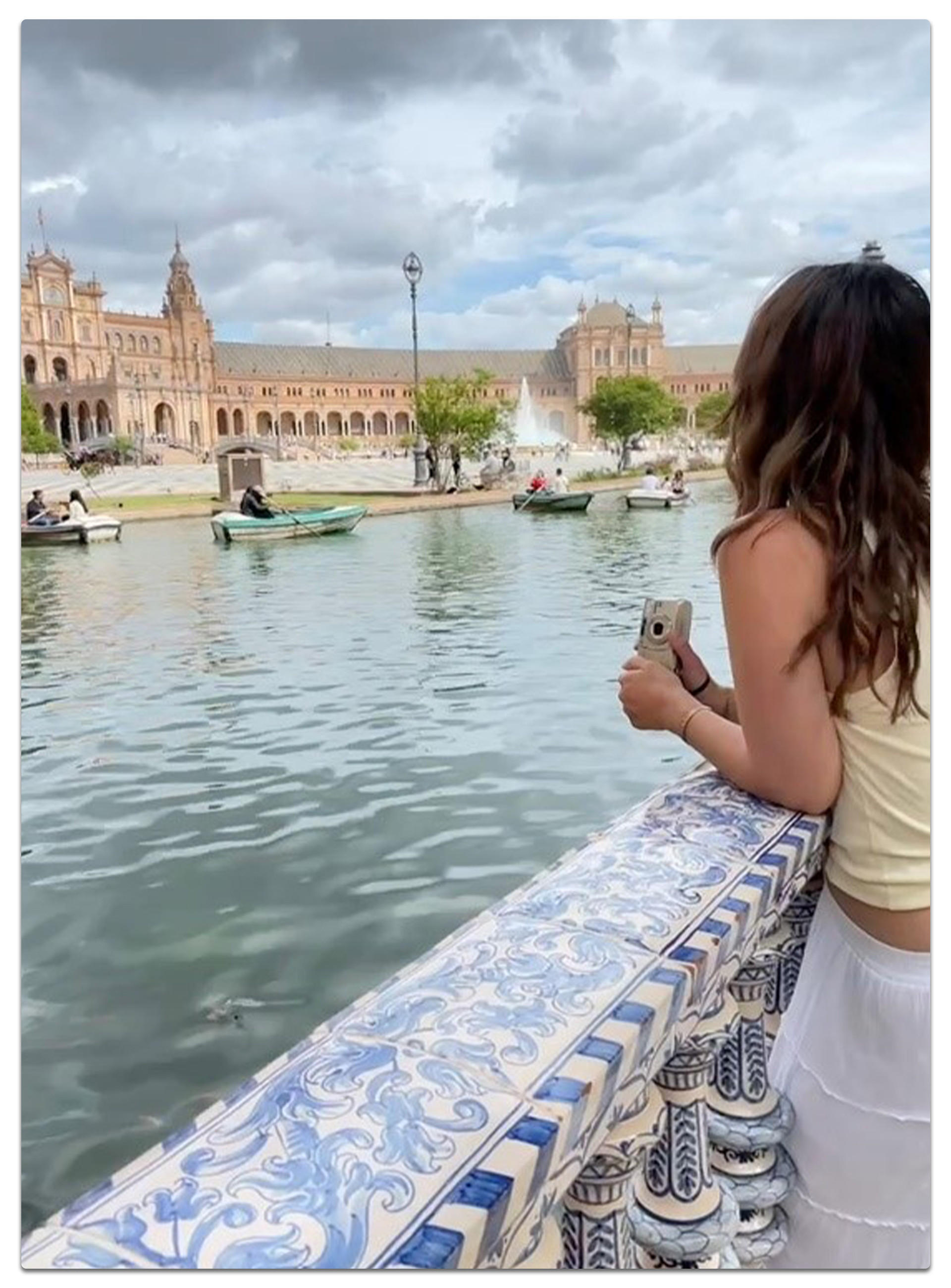 Svenja an kunstvoll verziertem Geländer mit Blick auf Boote und Wasser auf der Plaza de España in Sevilla, Spanien – beeindruckende Architektur und mediterranes Flair
