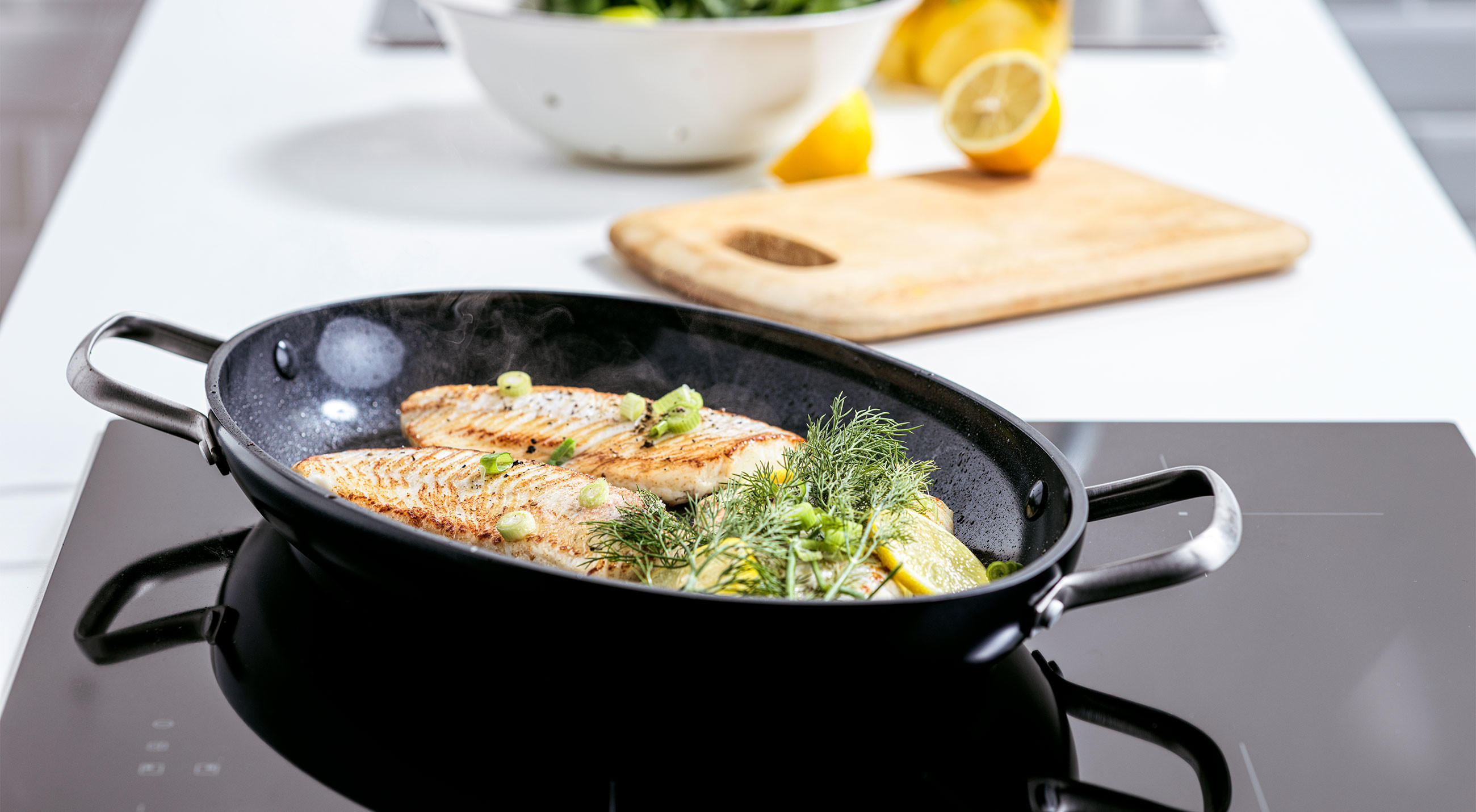 Eine Pfanne von GreenPan mit gegrilltem Fisch und einer Auswahl an Gemüse.