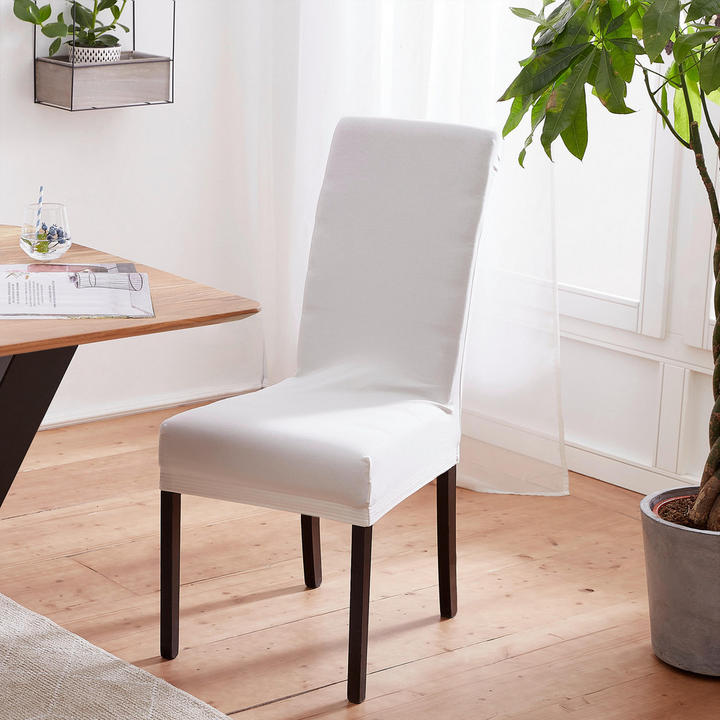 Pred mizo je bela stolica, oblečena v prevleko za stol.