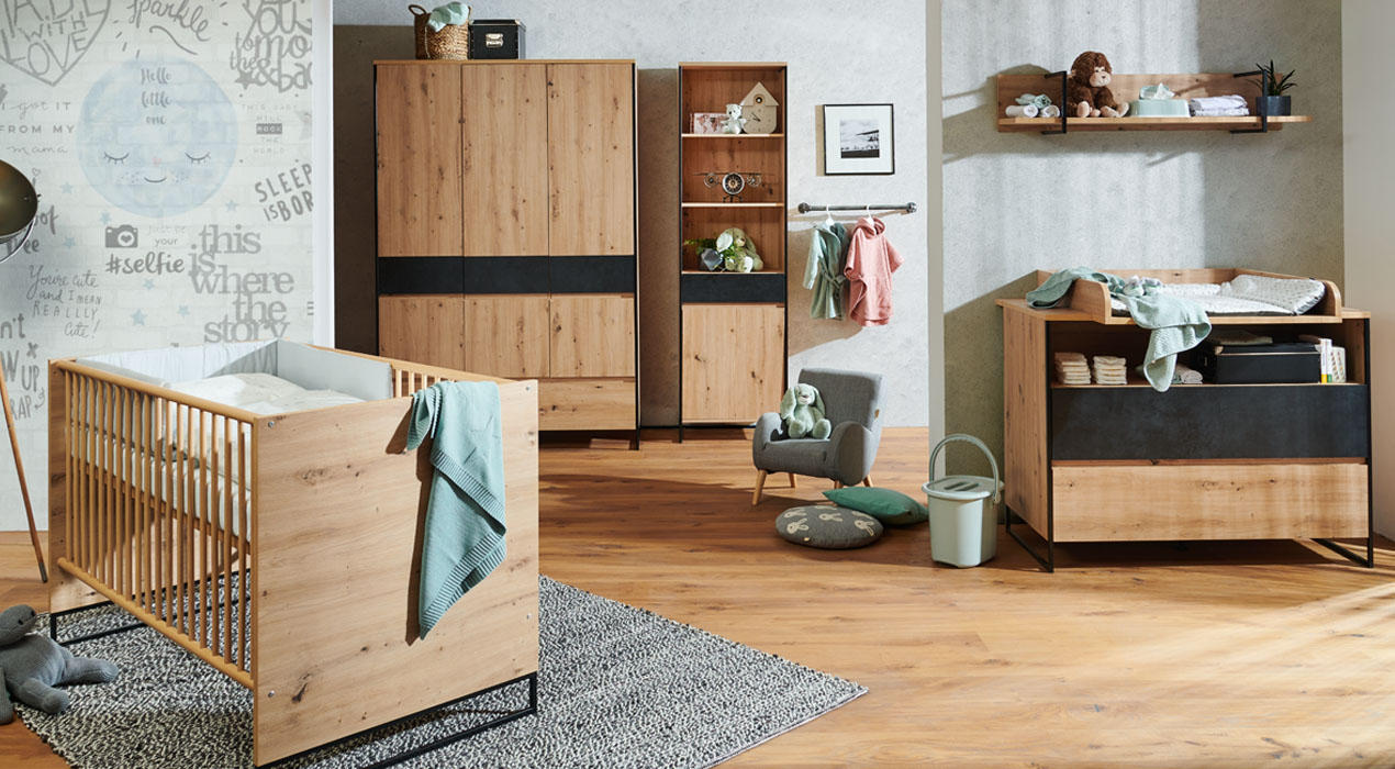 Liebevoll eingerichtetes Babyzimmer mit Möbeln aus Holz, darunter Schränke, Wickelkommode und ein Gitterbett. Dekoriert mit Spielzeug, Textilien und sanften Farbe