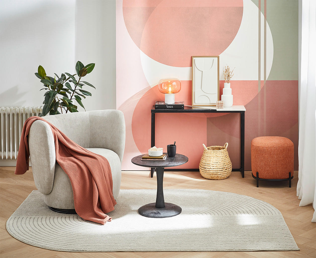 Modernes Wohnzimmer mit grauem Sessel, schwarzem Beistelltisch, orangefarbenem Pouf und dekorativer Konsole.