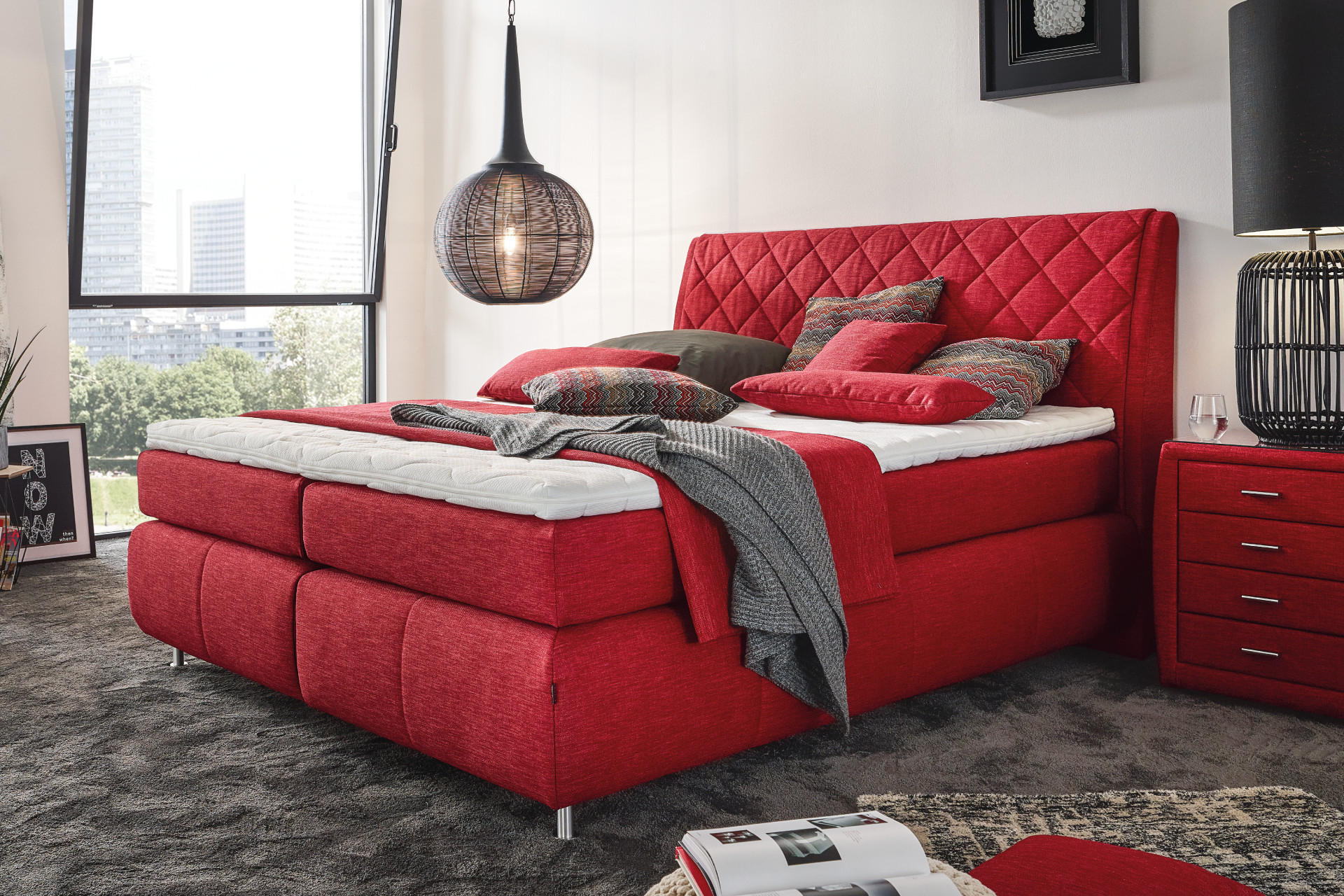 Červená postel boxspring s nočním stolkem
