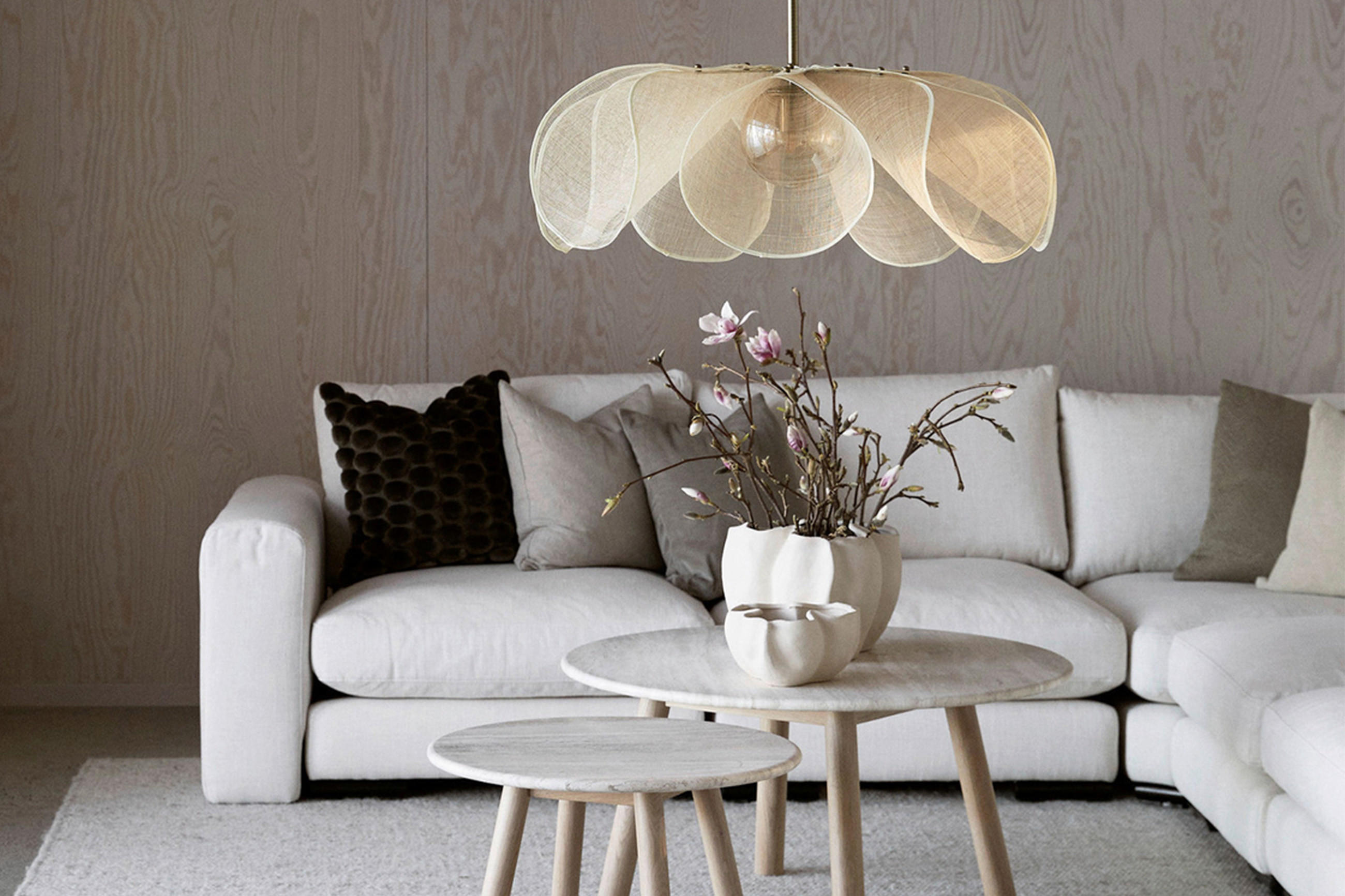 Stilvolles Wohnzimmer mit weißen Möbeln und einer modernen Lampe, die eine gemütliche Atmosphäre schafft..