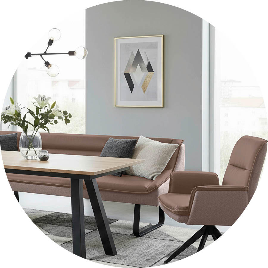 Esszimmer mit brauner Eckbank und passendem Stuhl vor grauer Wand mit abstraktem Bild und moderner Deckenleuchte