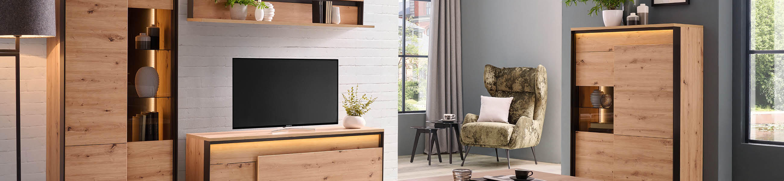 Modernes Wohnzimmer, ausgestattet mit Fernseher, bequemer Couch und einem stilvollen Holzschrank.