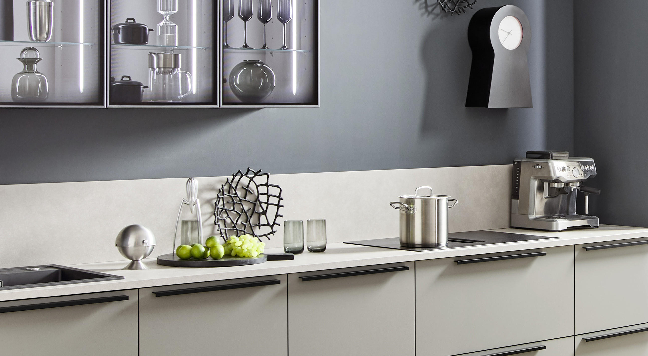 Stilvoll gestaltete Küche in abgestimmten Farben und passenden Formen der Fronten, Schränke und Küchenaccessoires.