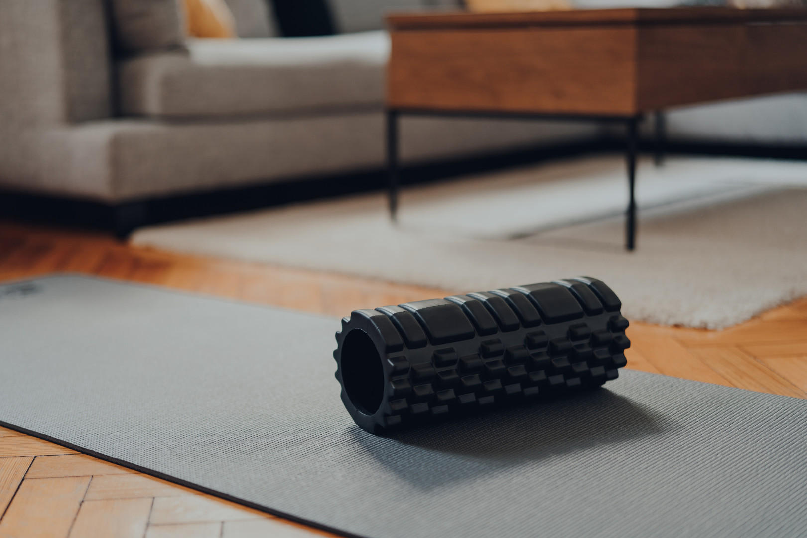 Auf dem Boden befinden sich eine Yogamatte und ein Roller, ideal für Übungen und Entspannung.