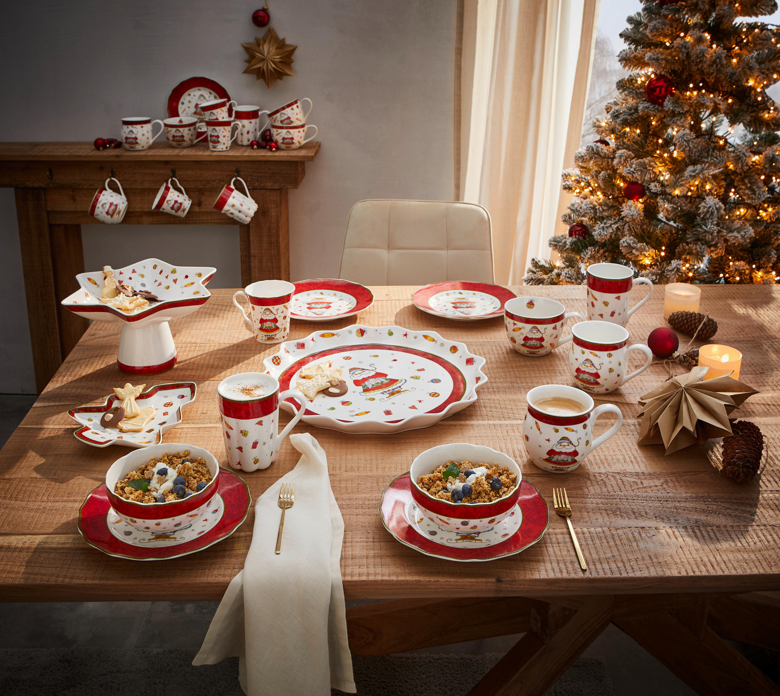 Miza okrašena za božič, s prazničnimi dekoracijami in svečami, pripravljena za praznično večerjo.