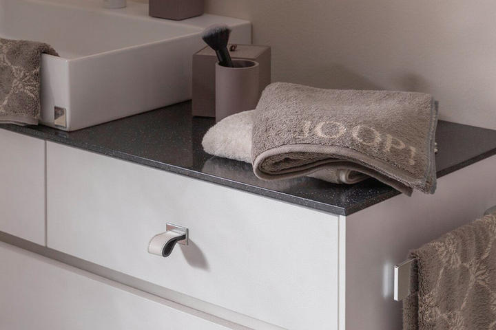 schwarzer Badezimmerschrank mit braunen Handtüchern