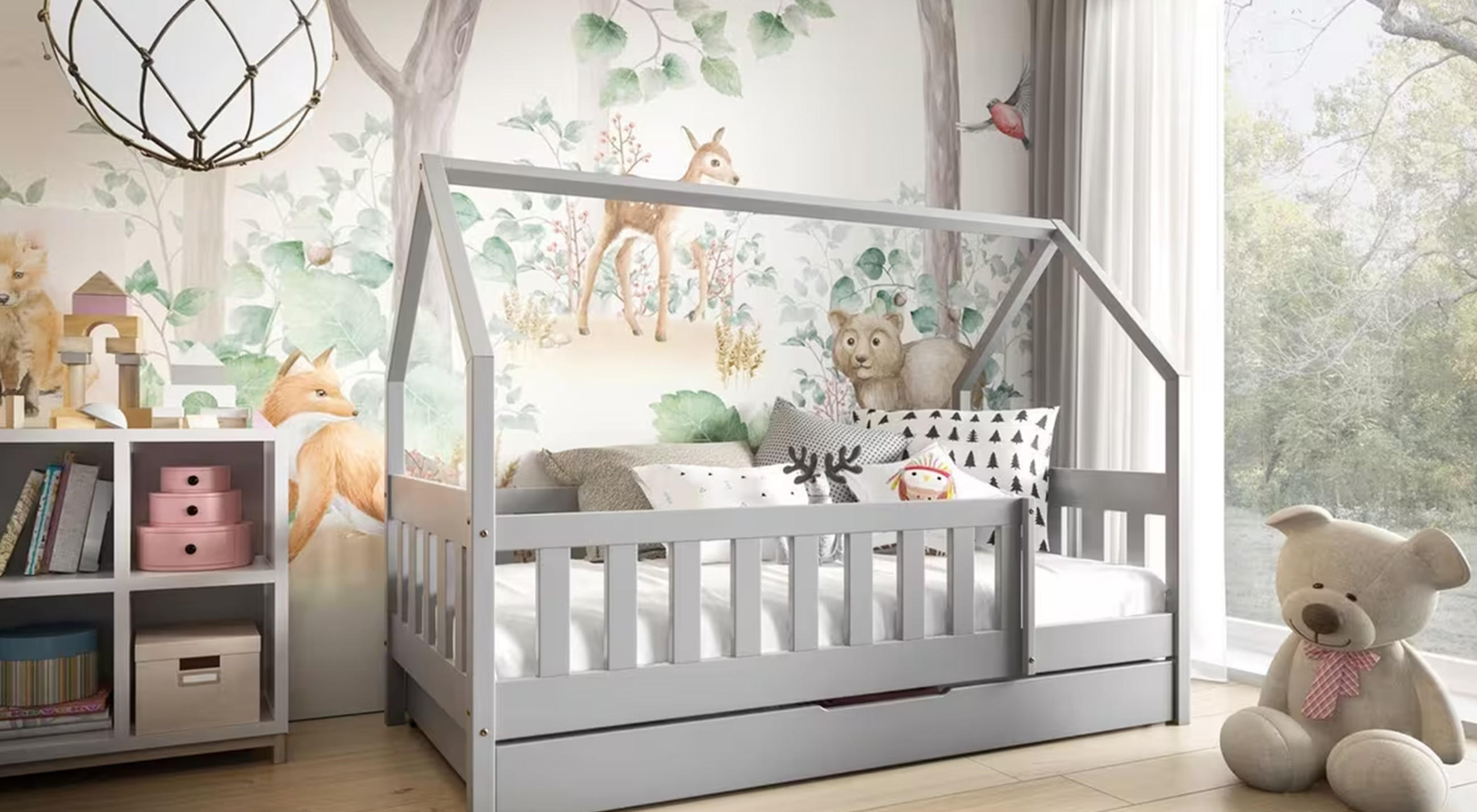 Kinderzimmer mit Hausbett, Regal mit Spielzeug und großem Teddybär vor Fenster.