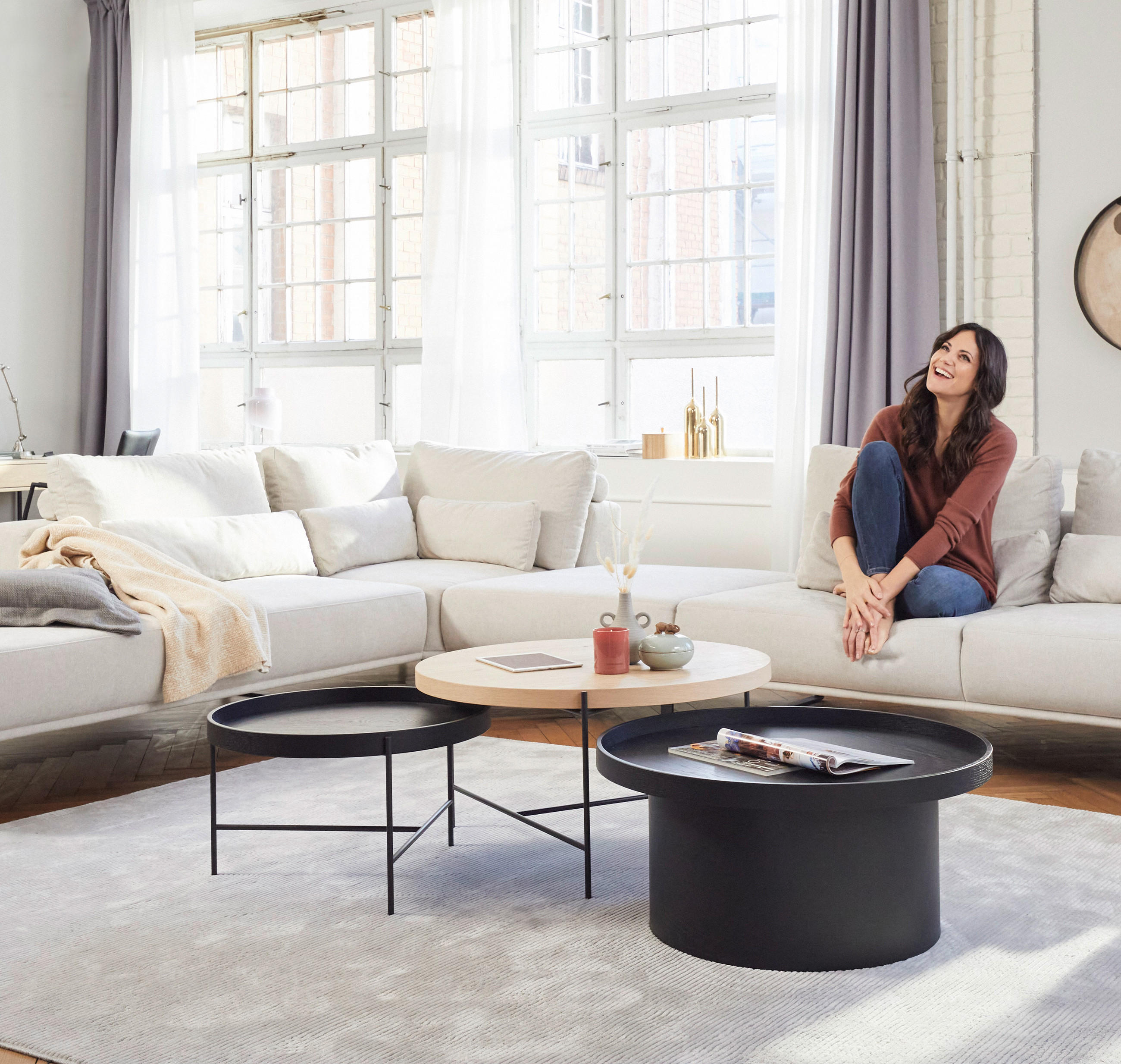Eine Frau sitzt auf einer Couch in einem Wohnzimmer