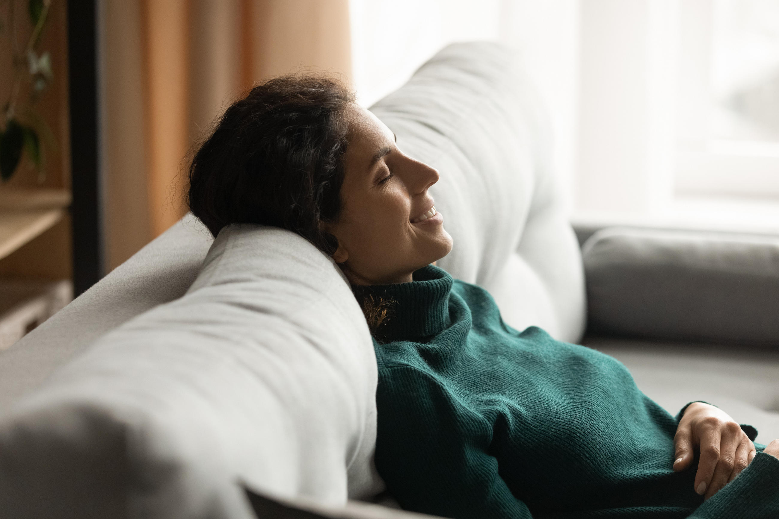 Eine Frau, die auf einem grauen Sofa entspannt